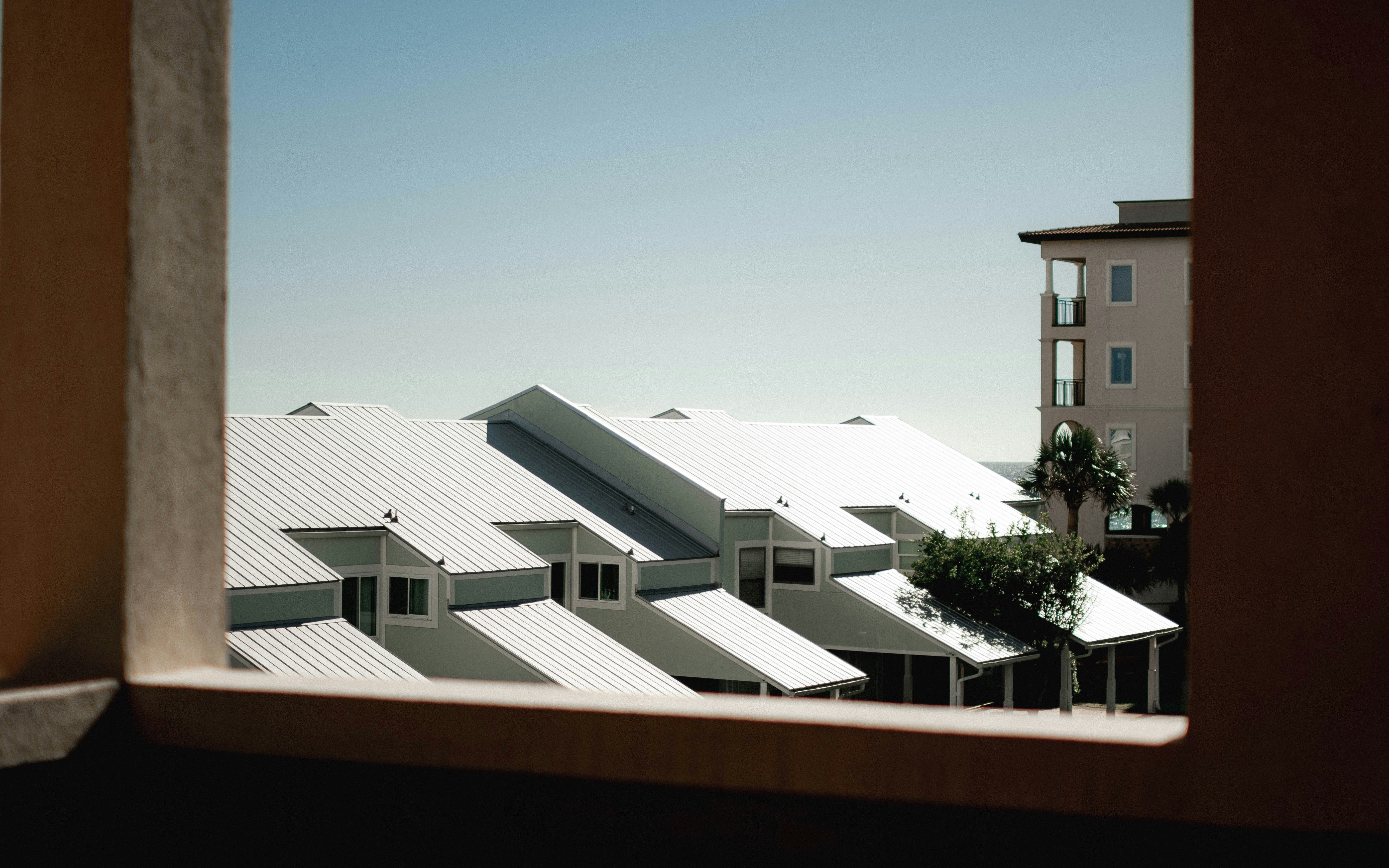 A view out a window of a building with snow on the roof