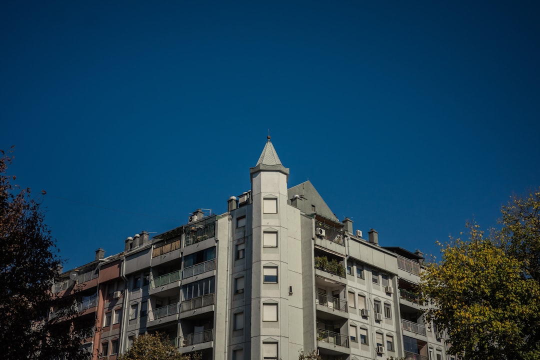 A tall building sitting next to a lush green forest,