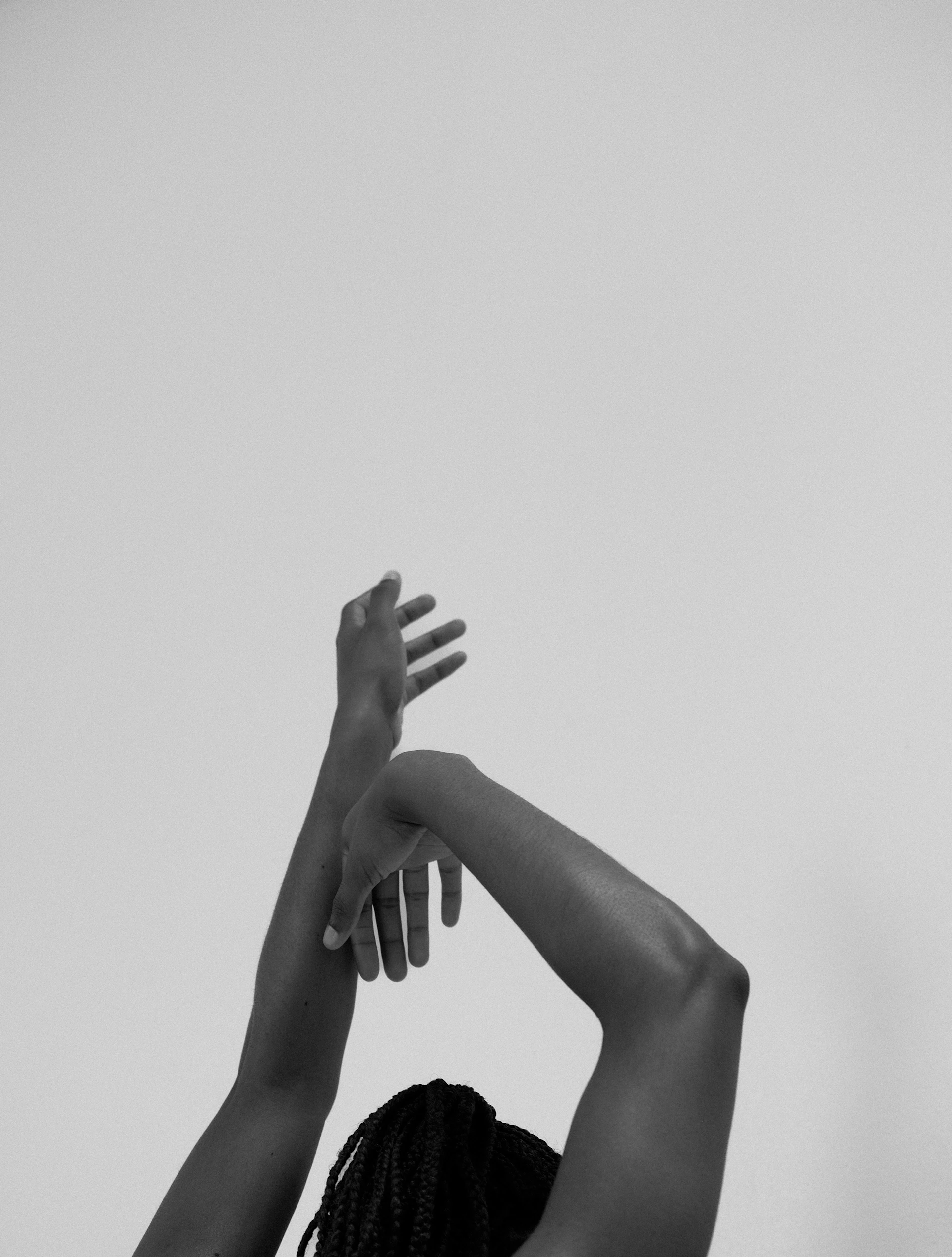 A woman reaching up into the air to catch a frisbee