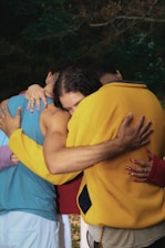 A group of people hugging each other outside