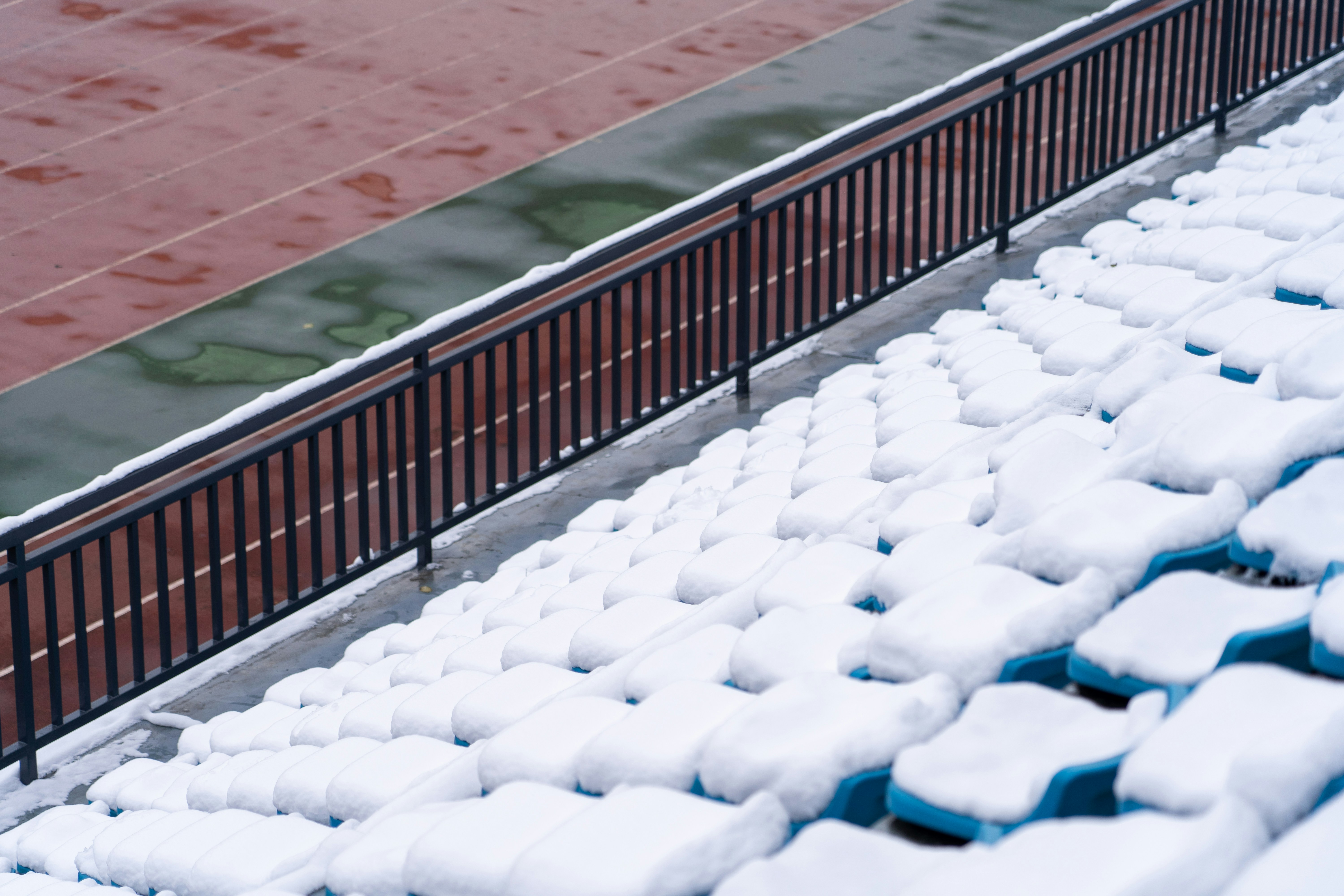 フェンスの横の雪に覆われたテニスコート