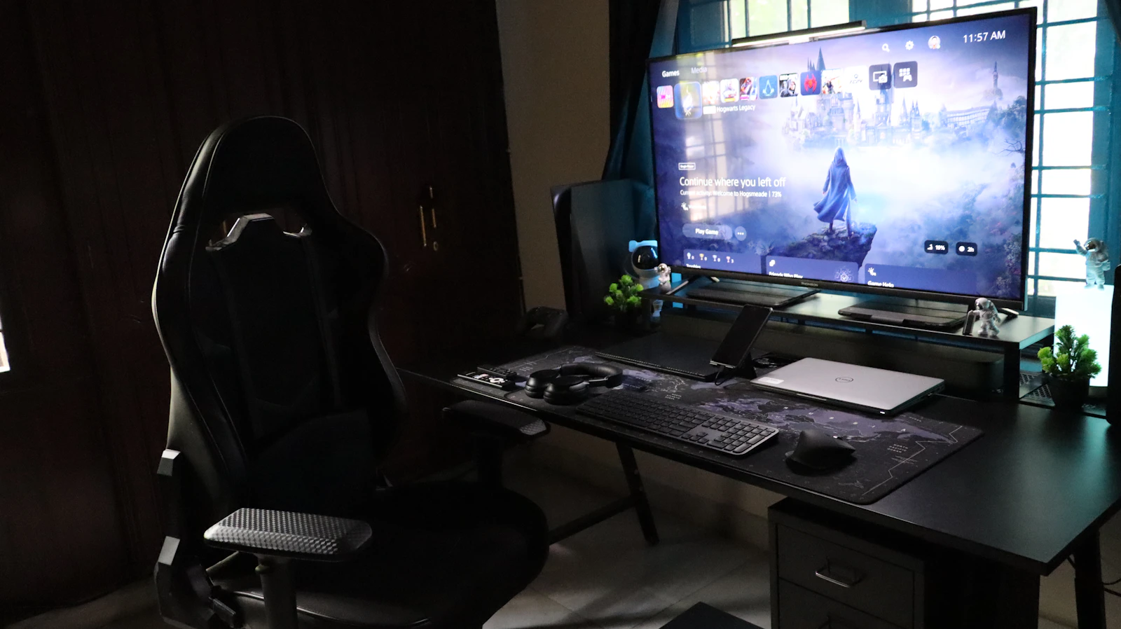 Real modern gaming desk with a large monitor, keyboard, console hardware, and organized gaming equipment