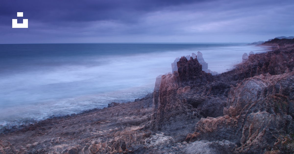 A blurry photo of the ocean and rocks photo – Free Rock pool bay Image ...