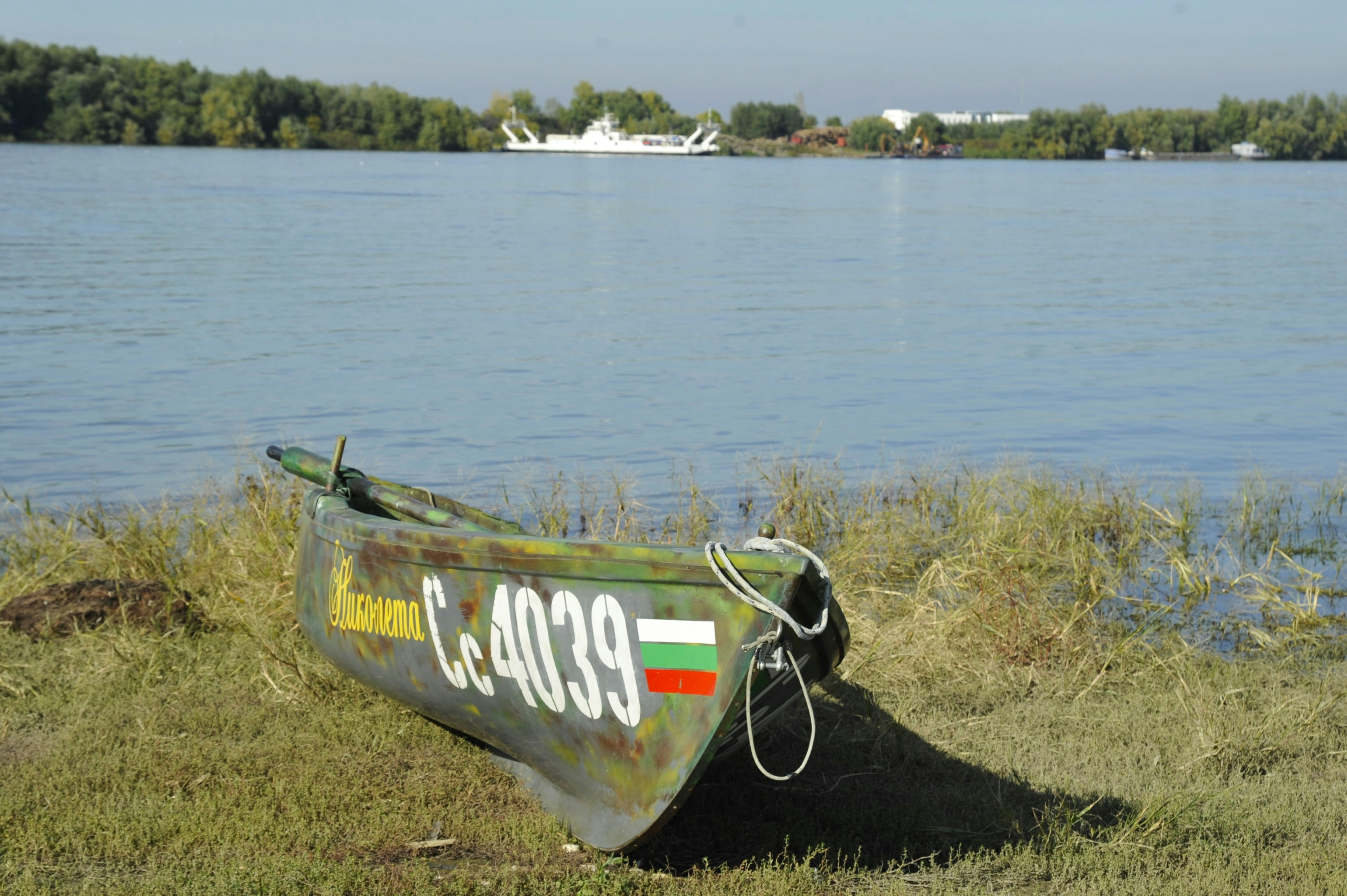 A small boat sitting on top of a grass covered field