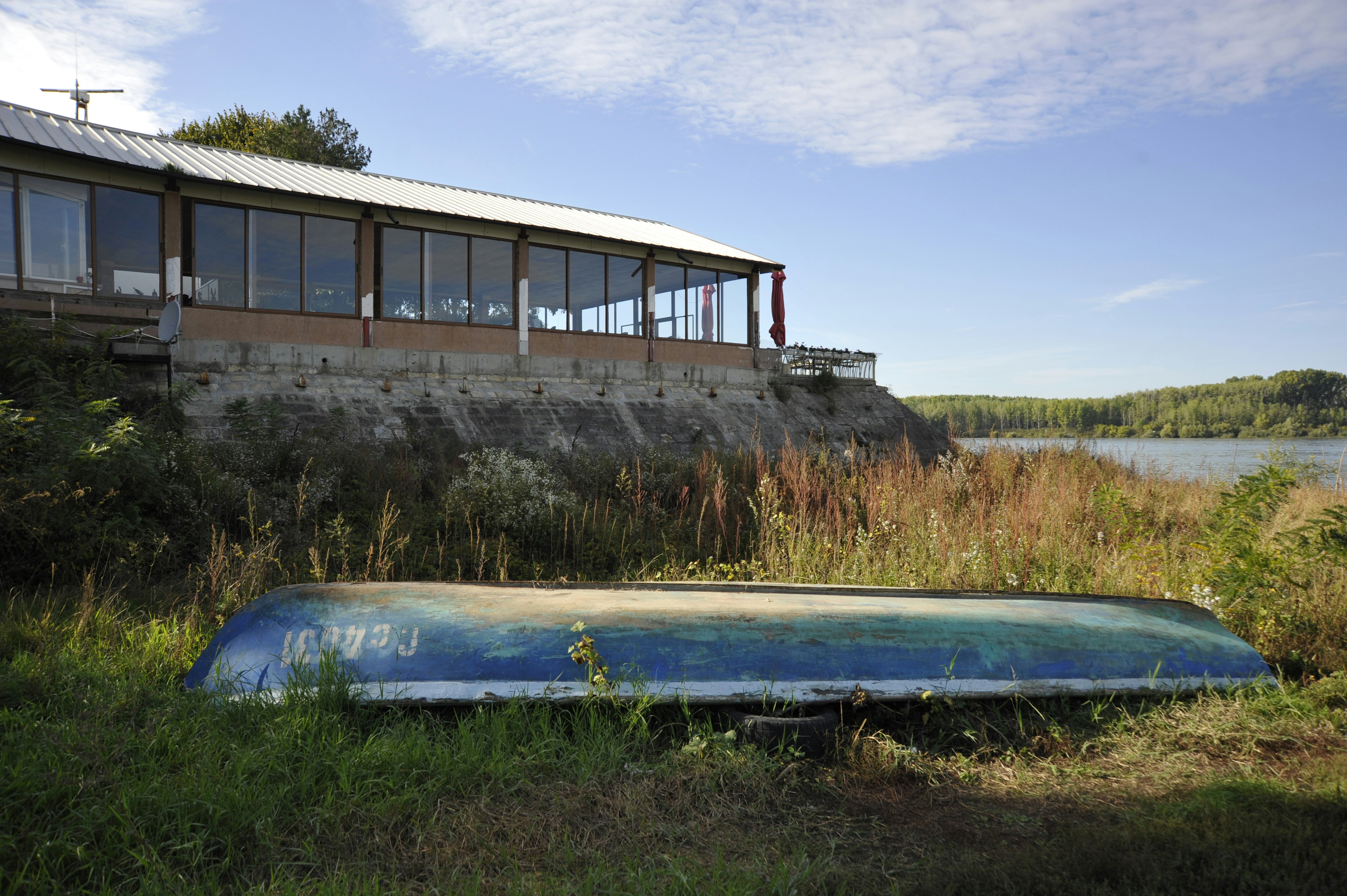 A boat sitting in the grass next to a building