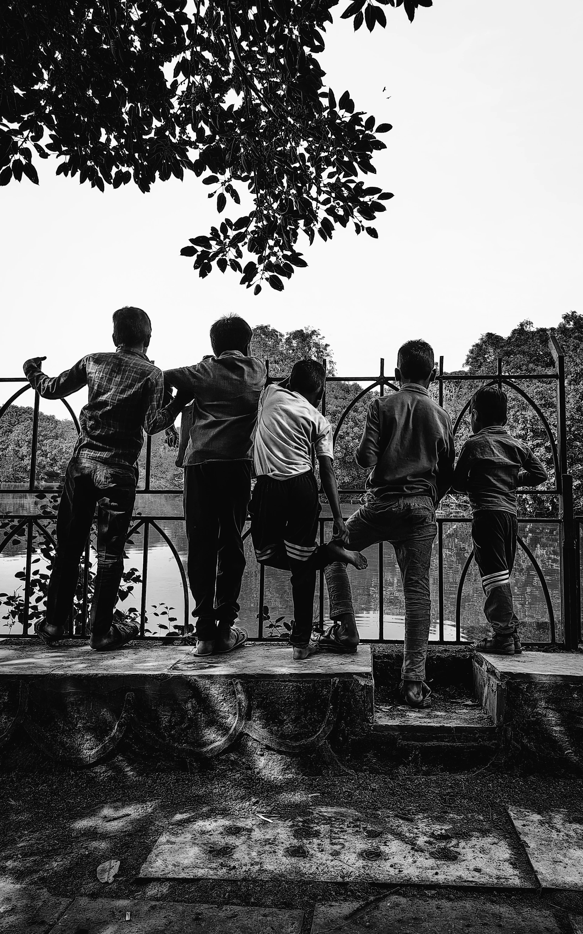 A group of young men standing on top of a stone wall