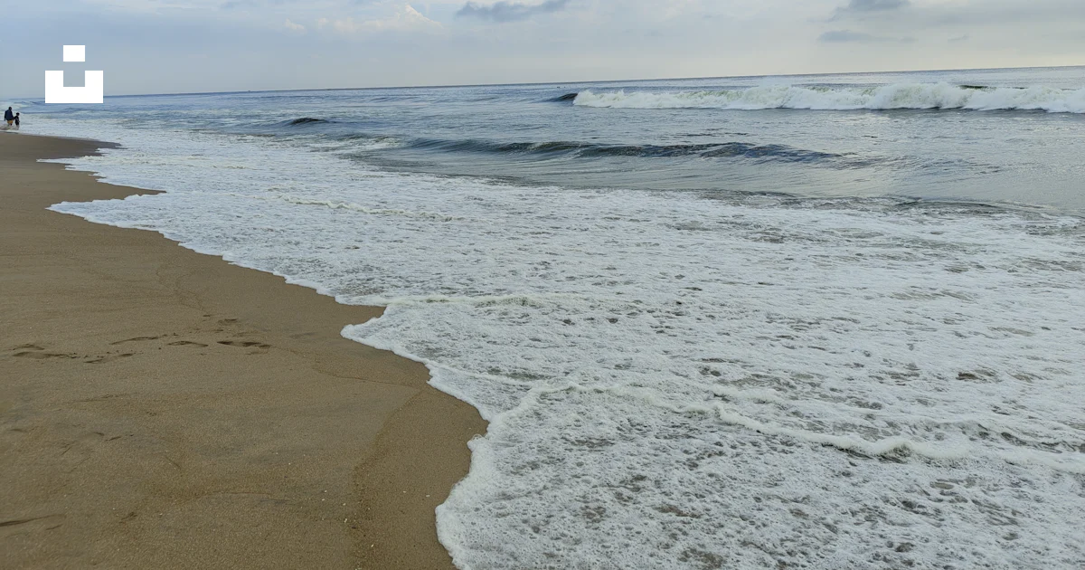 Une plage de sable avec des vagues qui arrivent sur le rivage photo ...