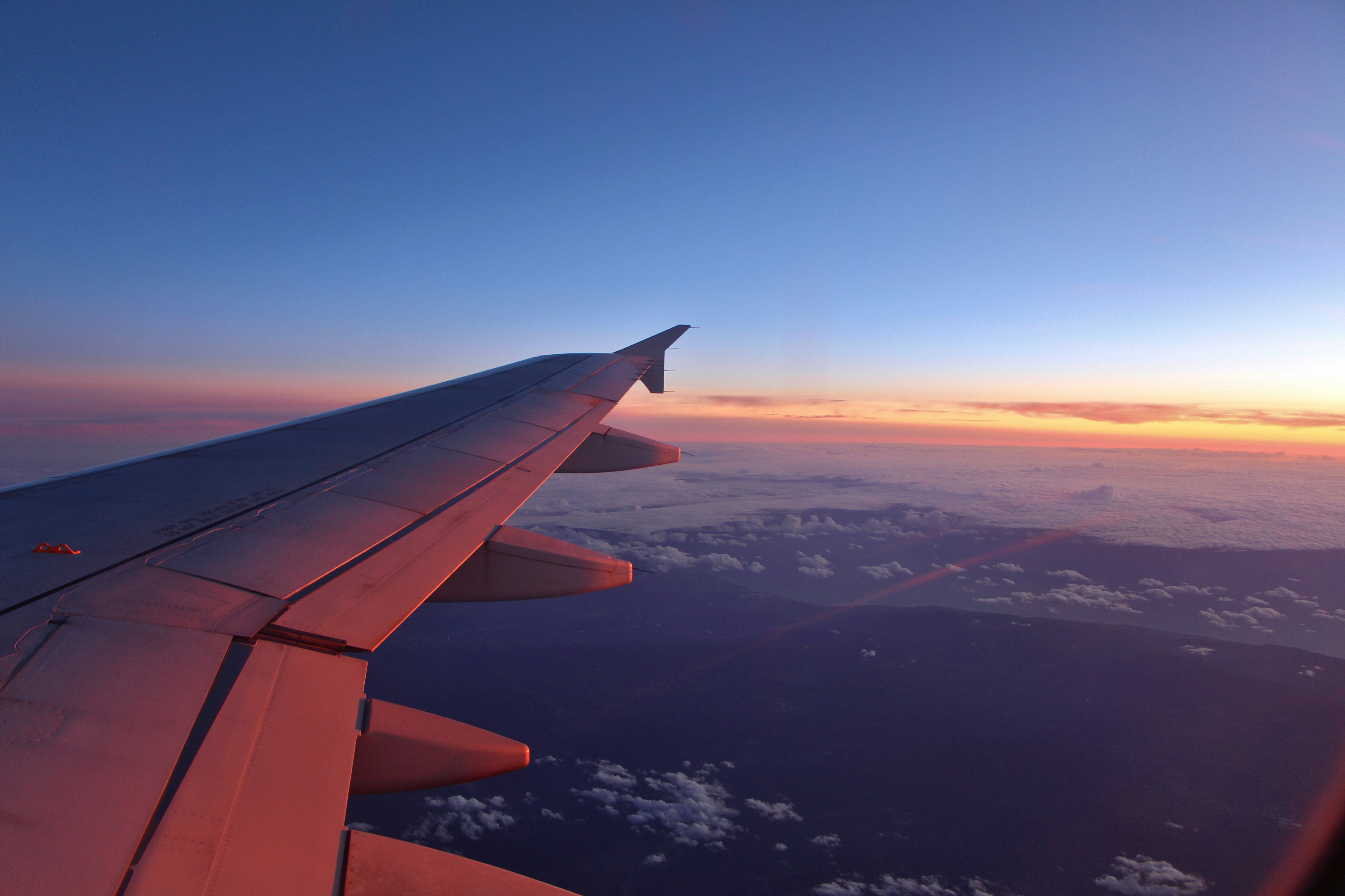 A view of the wing of an airplane at sunset