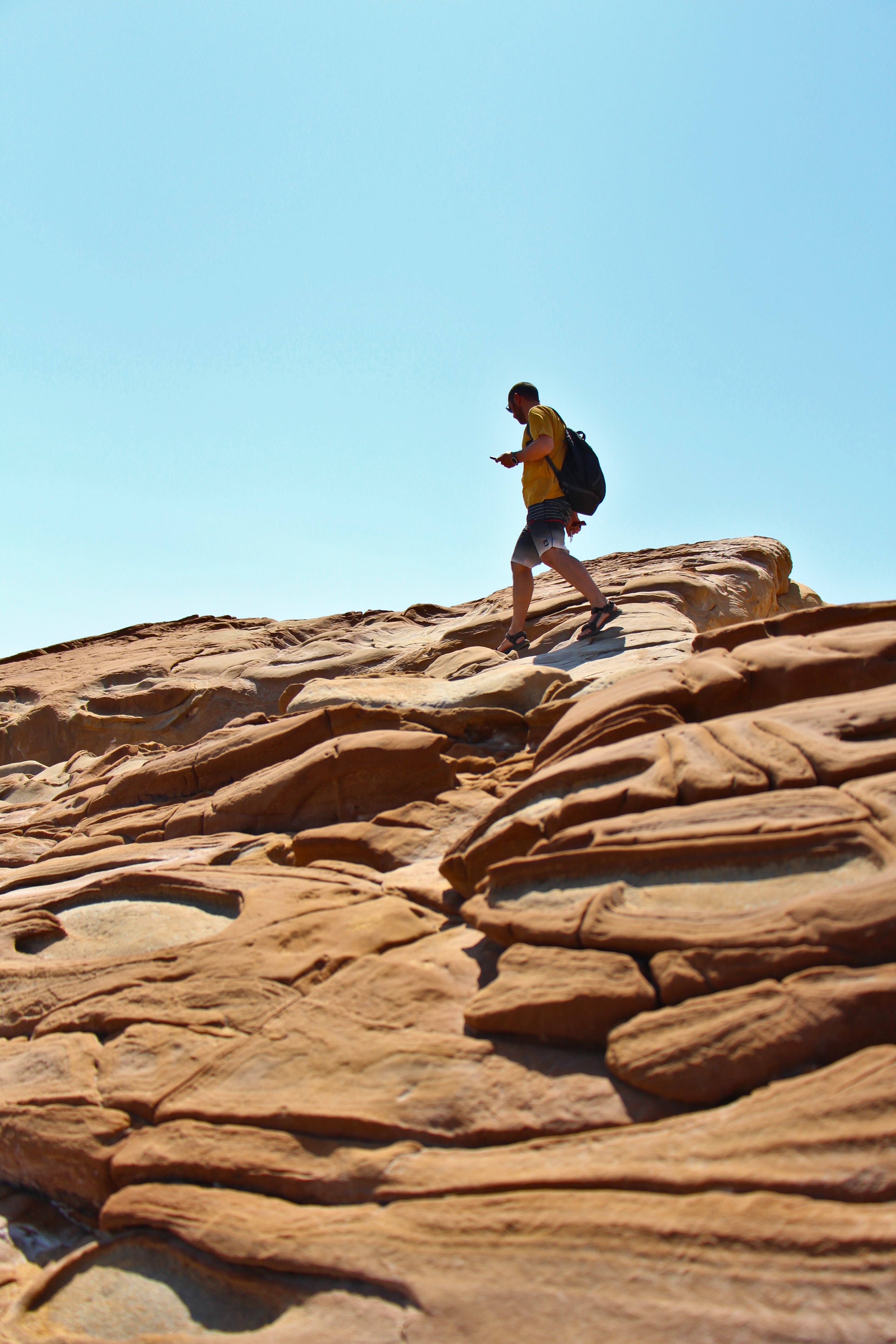 A person walking on a rock formation in the desert