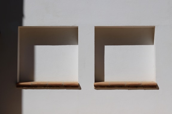 A couple of white boxes sitting on top of a white wall