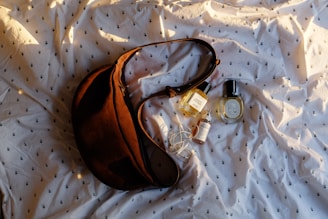 A brown purse sitting on top of a white sheet