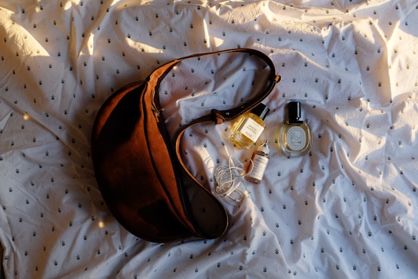 A brown purse sitting on top of a white sheet