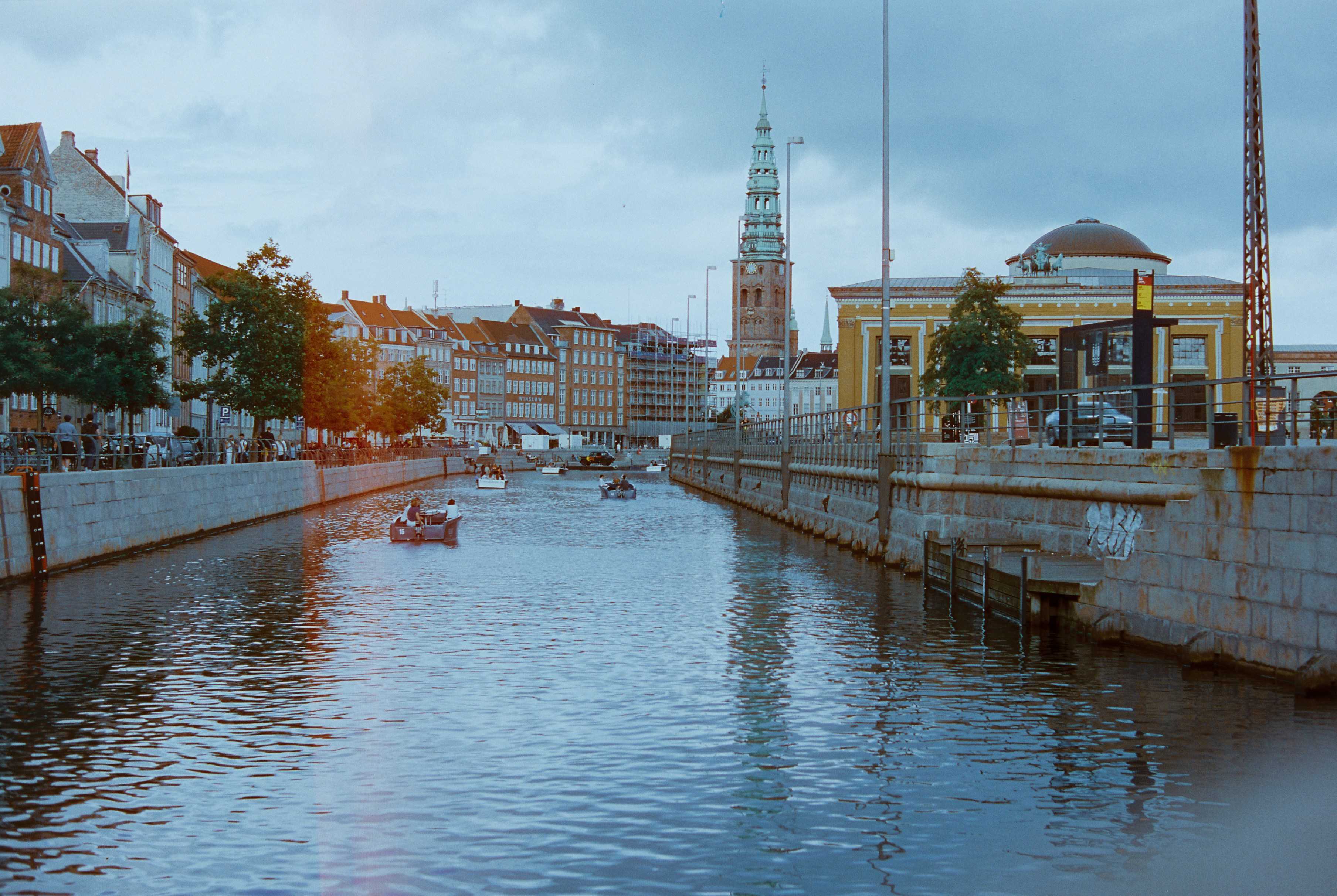 A river running through a city next to tall buildings, 