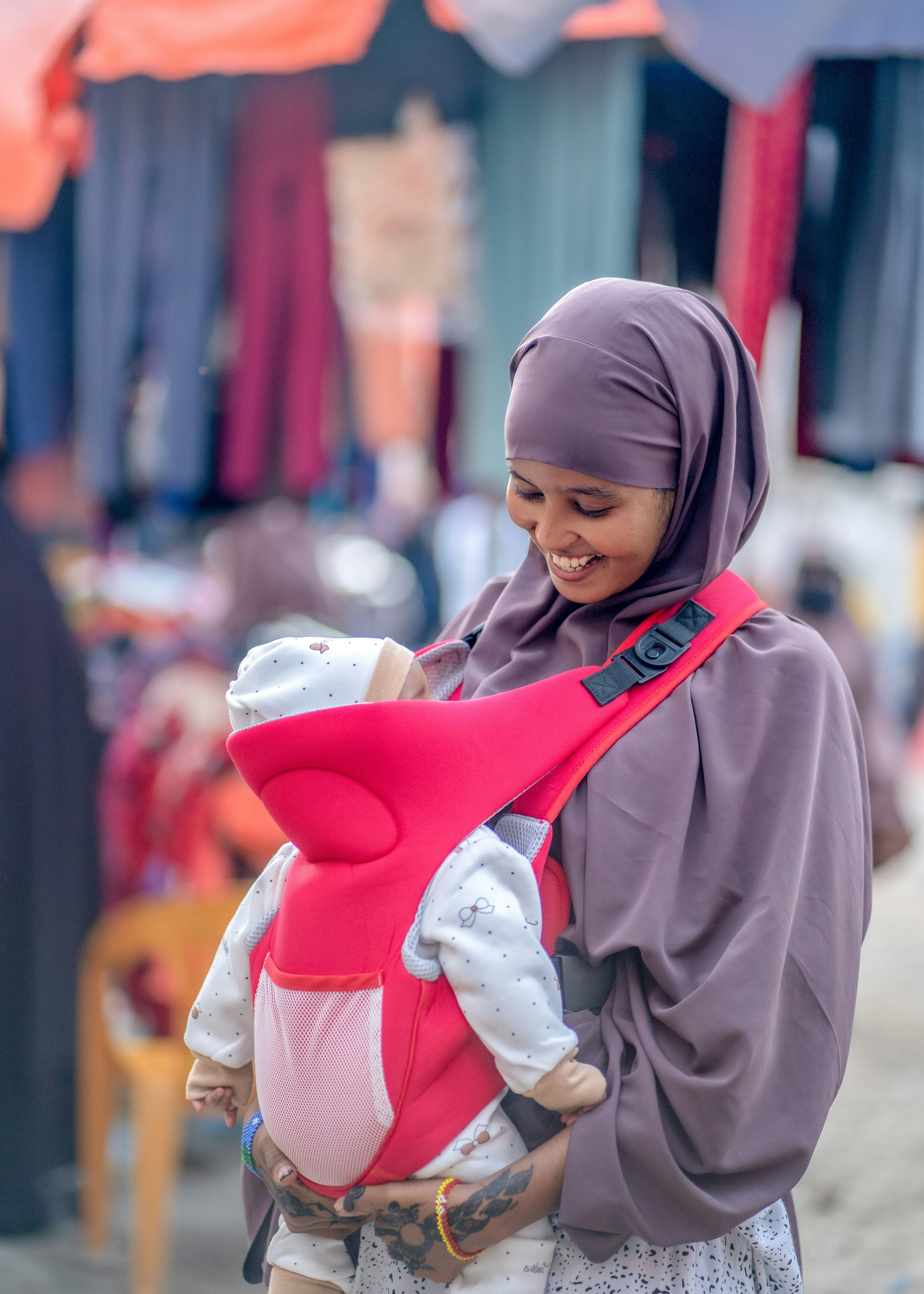 A woman carrying a baby in a sling