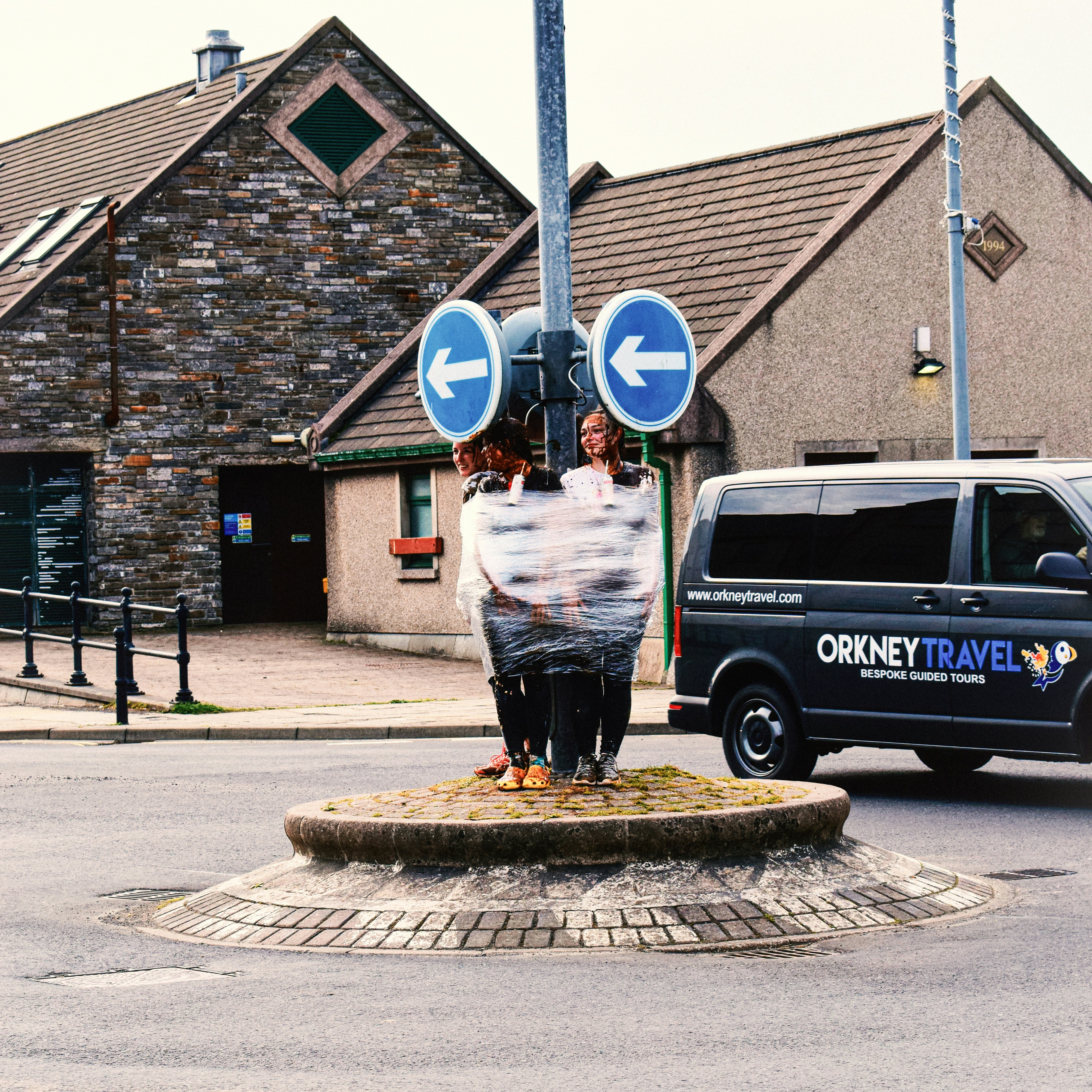 A man sitting on top of a fountain next to a van