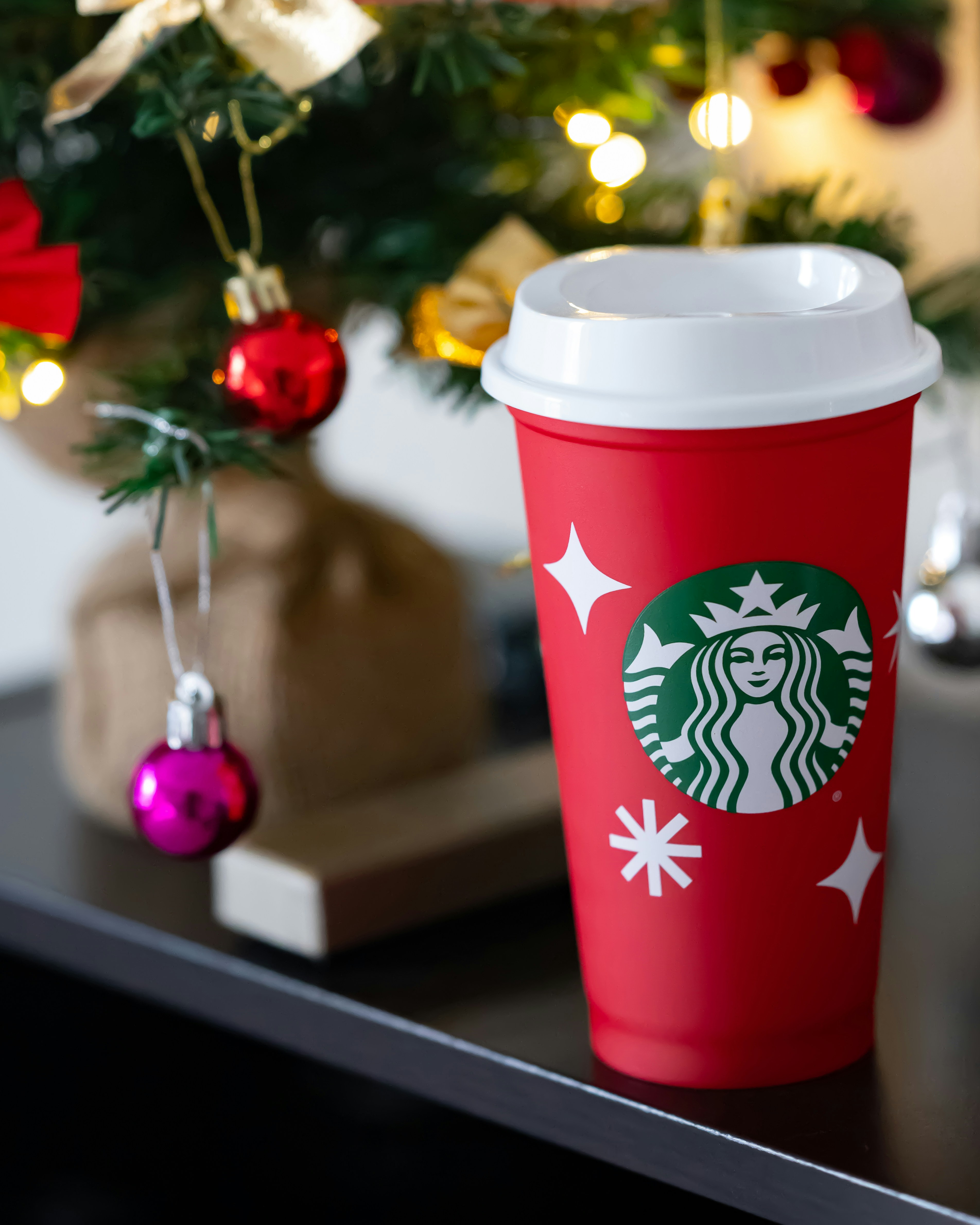 Una taza roja de Starbucks encima de una mesa