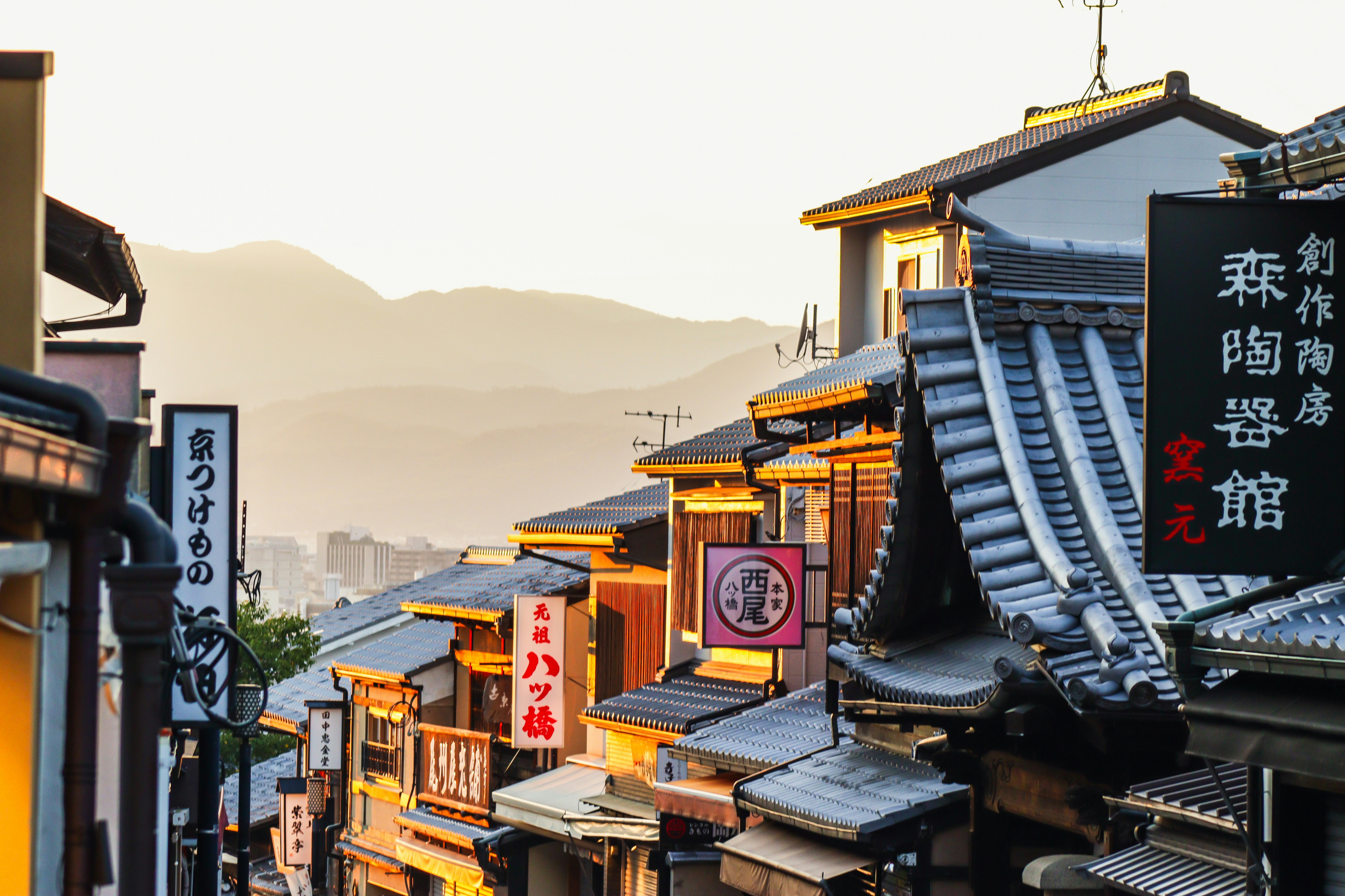 A city street lined with tall buildings with asian writing on them