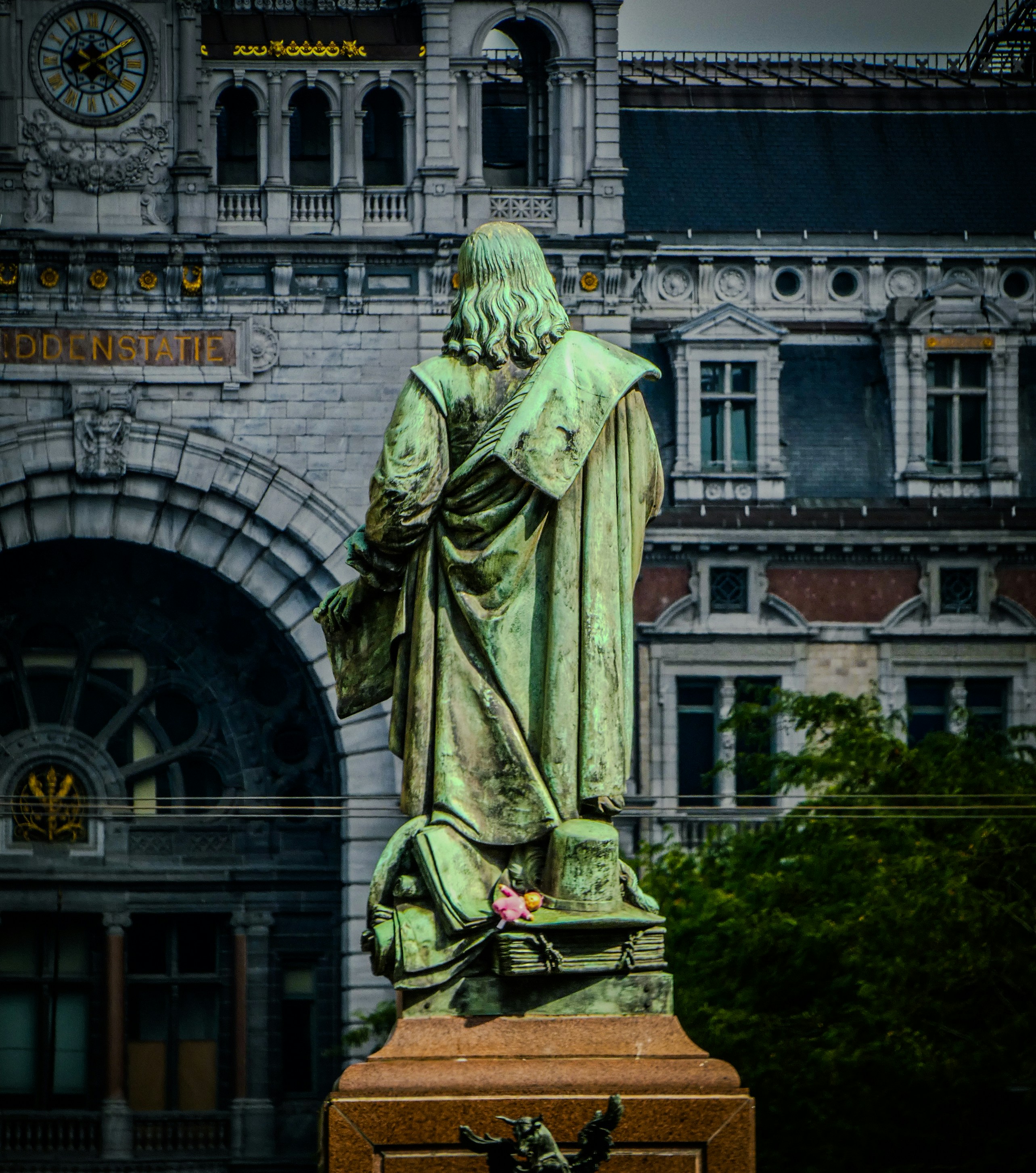 A statue of a man holding a box in front of a building