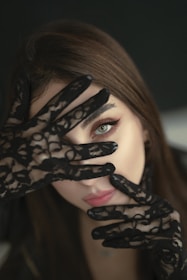A woman with black gloves covering her face
