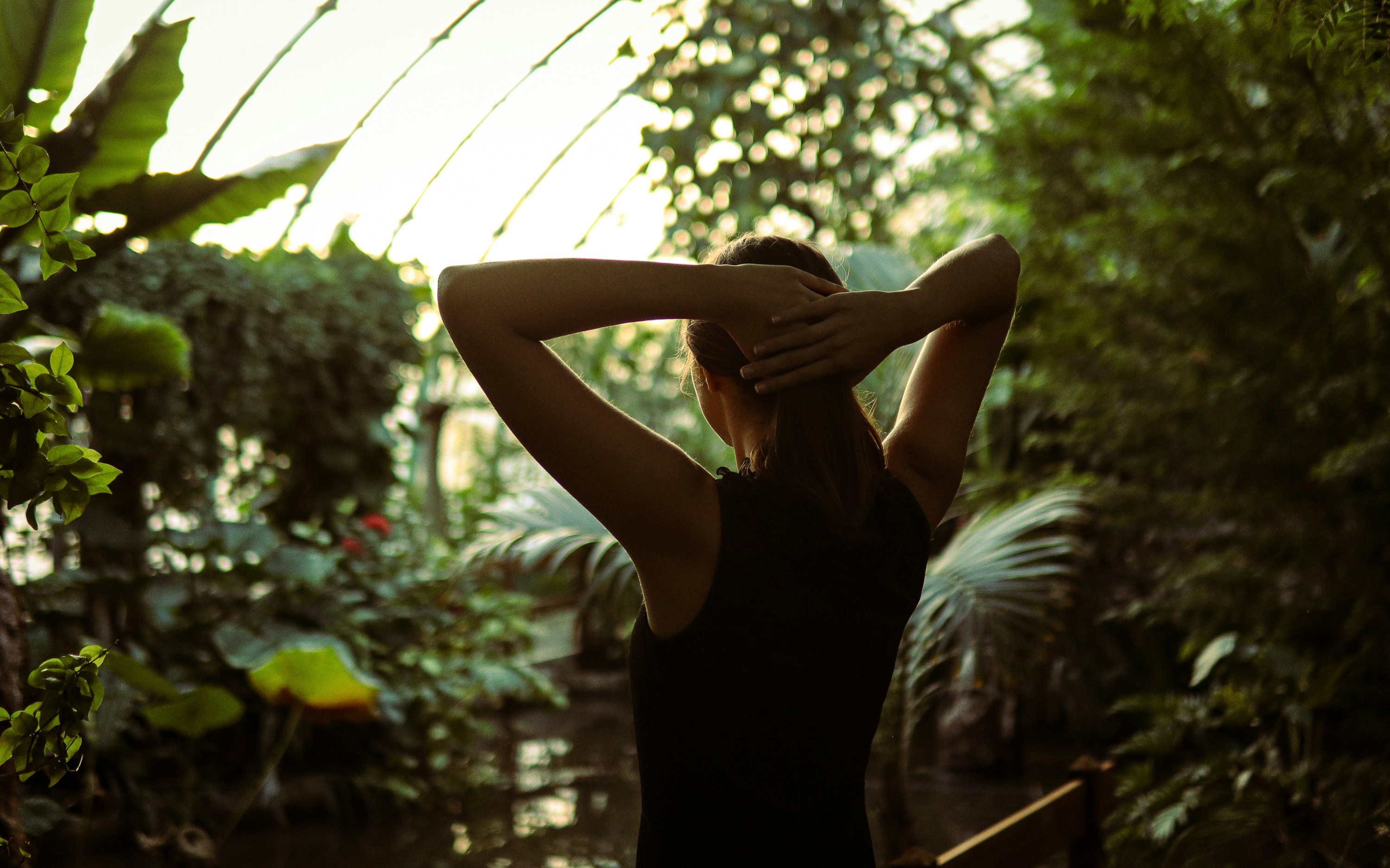 Una mujer con un vestido negro de pie en un invernadero