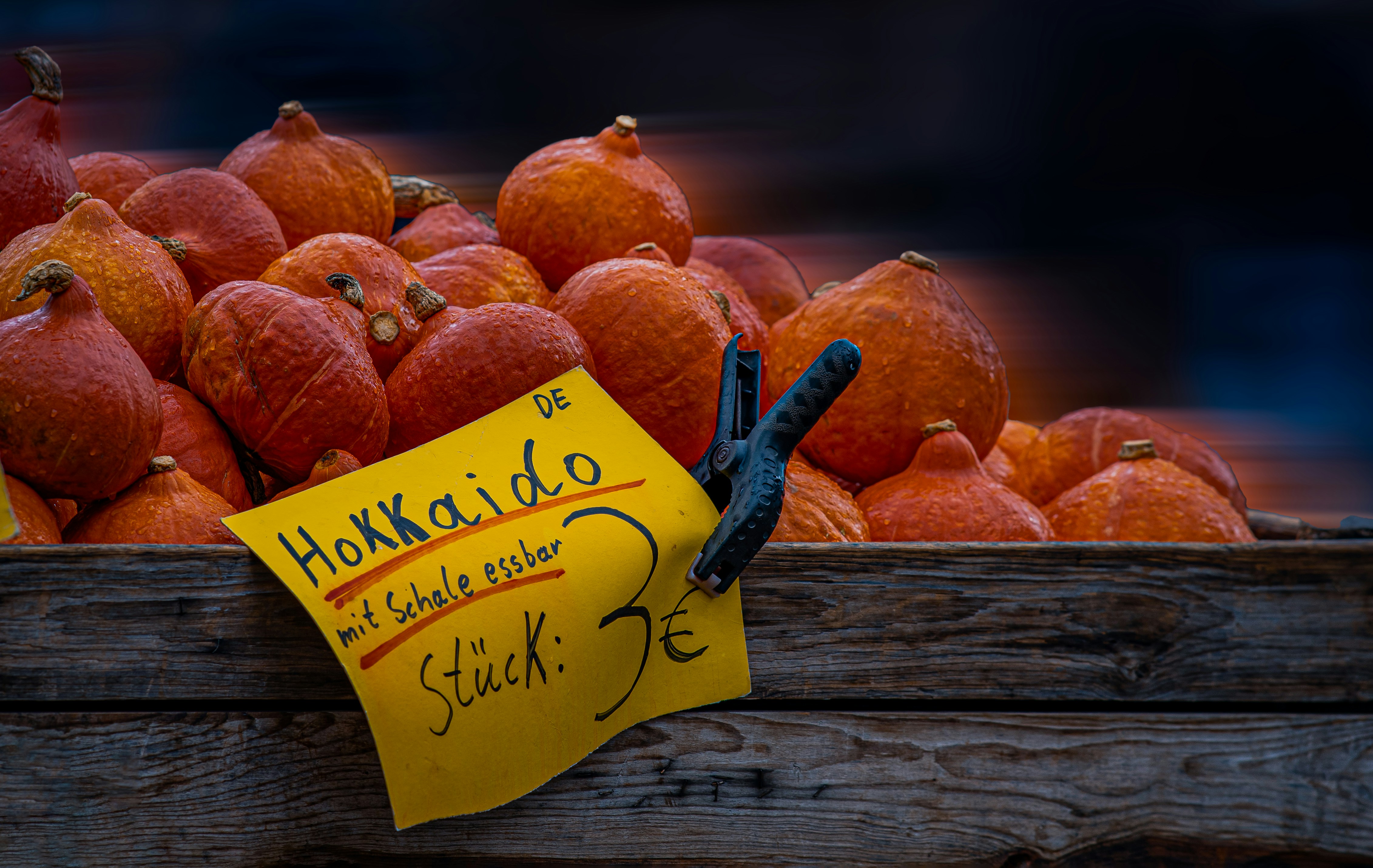 A wooden crate filled with lots of oranges