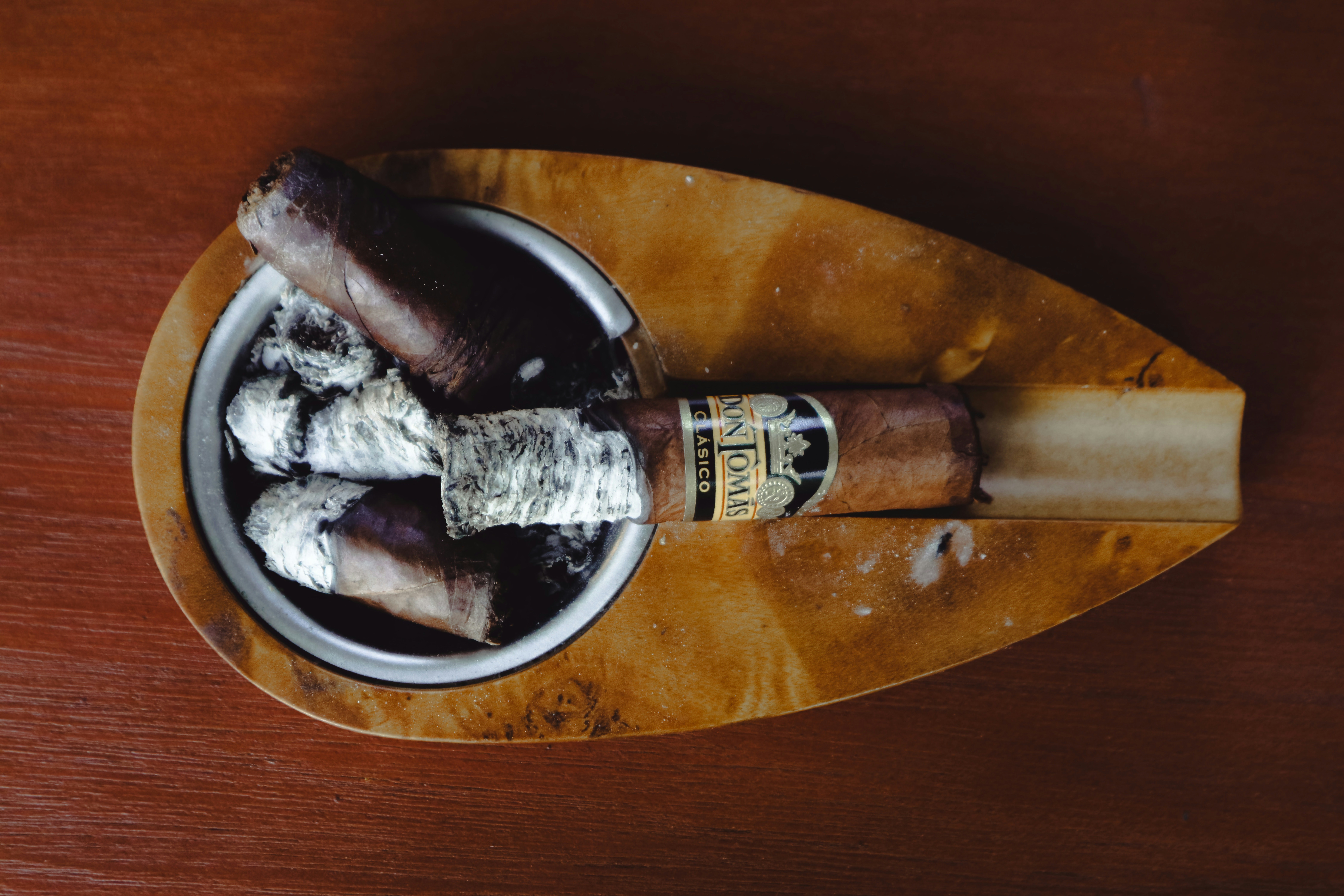 A wooden tray holding a couple of cigars