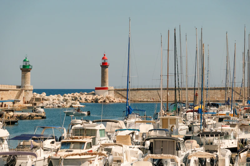 Port méditerranéen au coucher du soleil, bateaux et phare