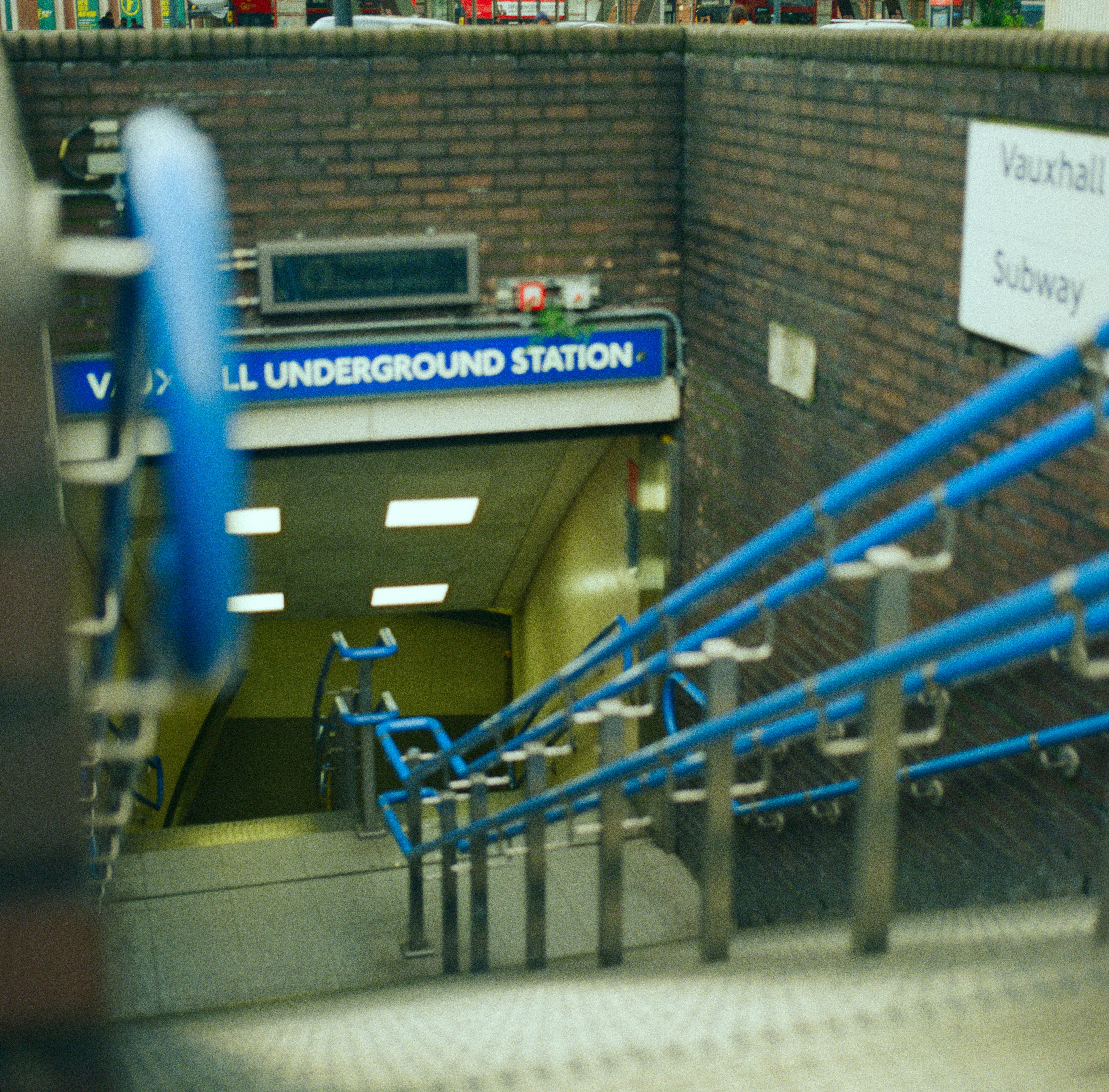 An underground station with blue railings and a sign