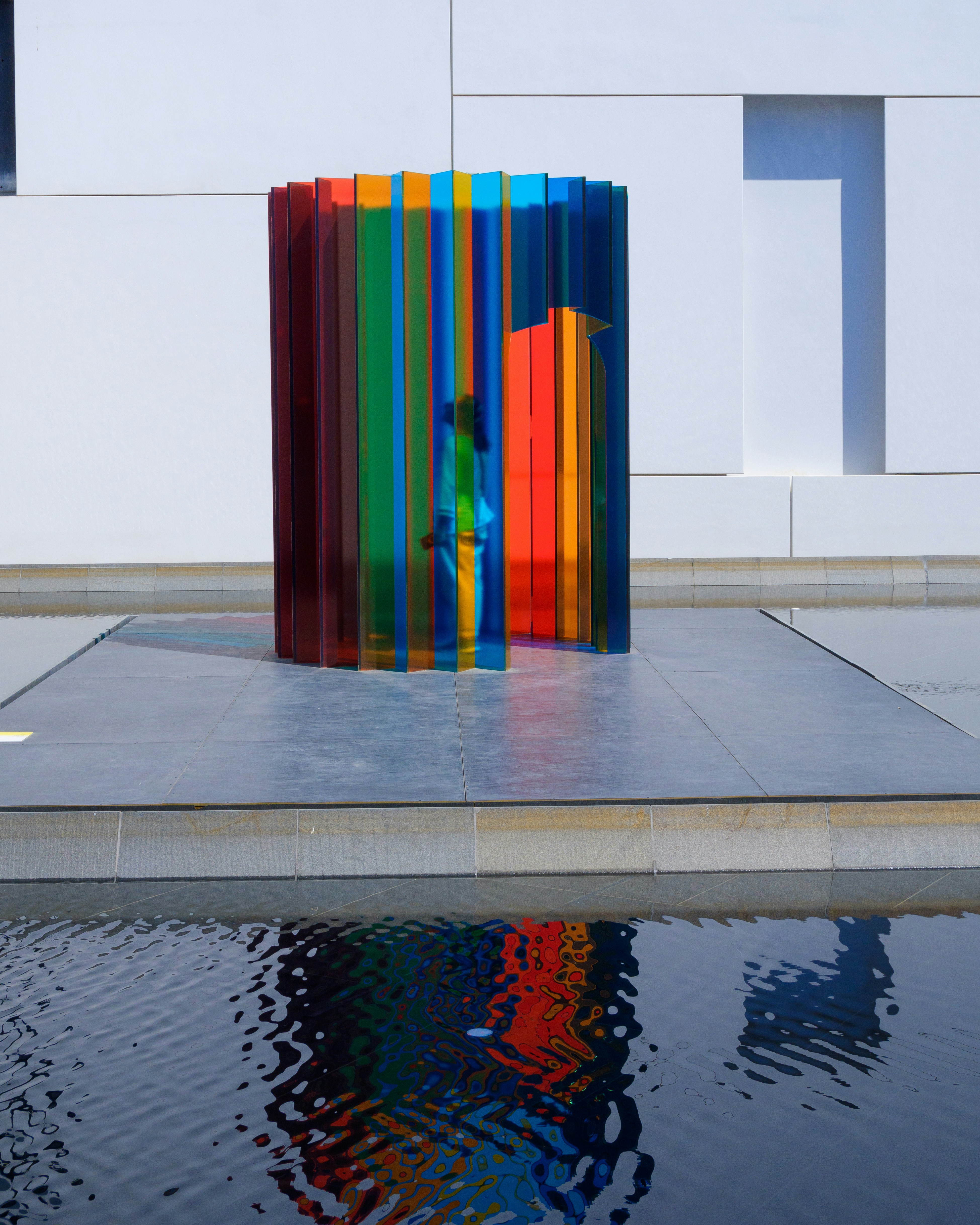 A colorful sculpture sitting on top of a pool of water