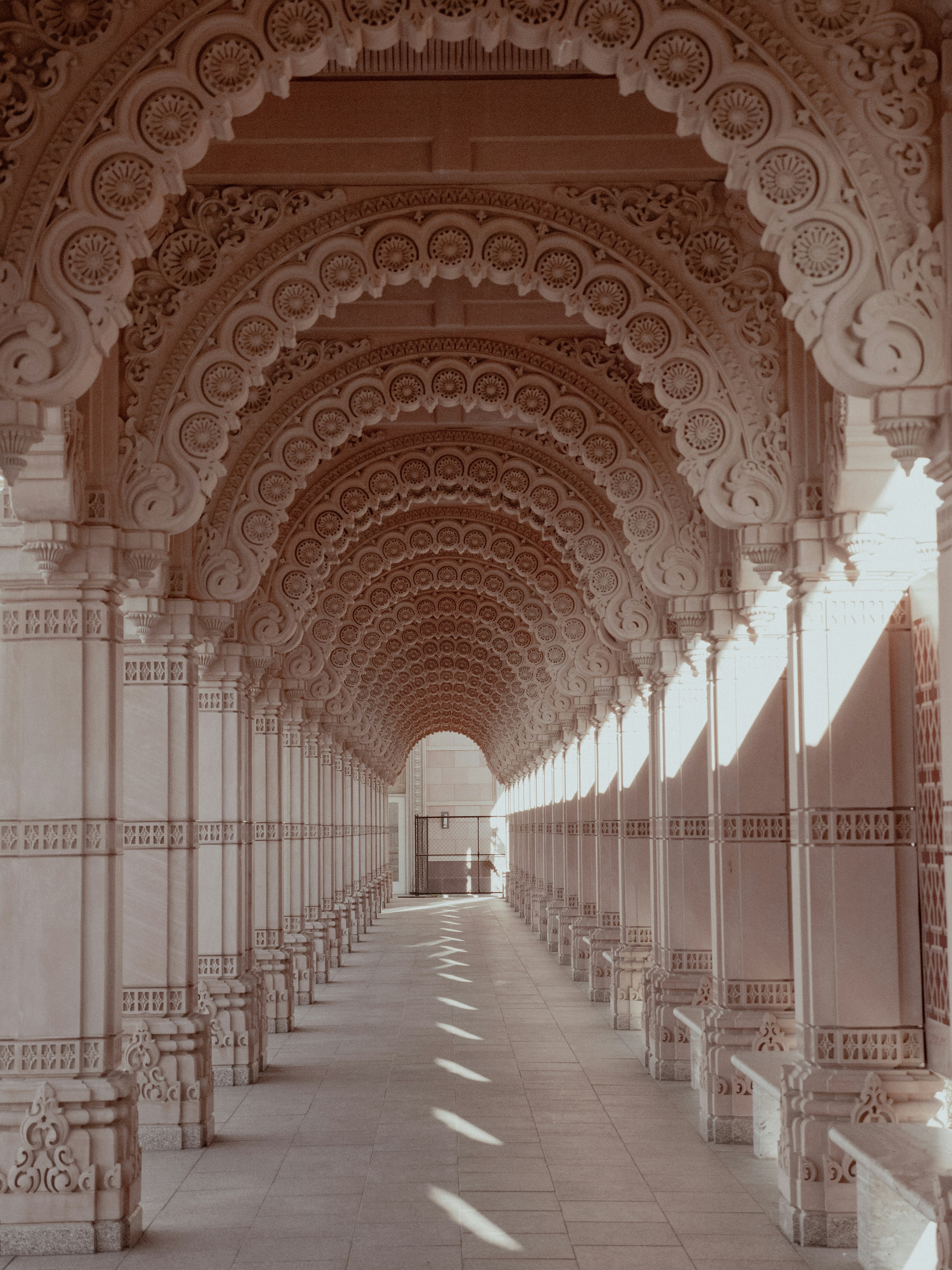 A long hallway with arches and benches on both sides