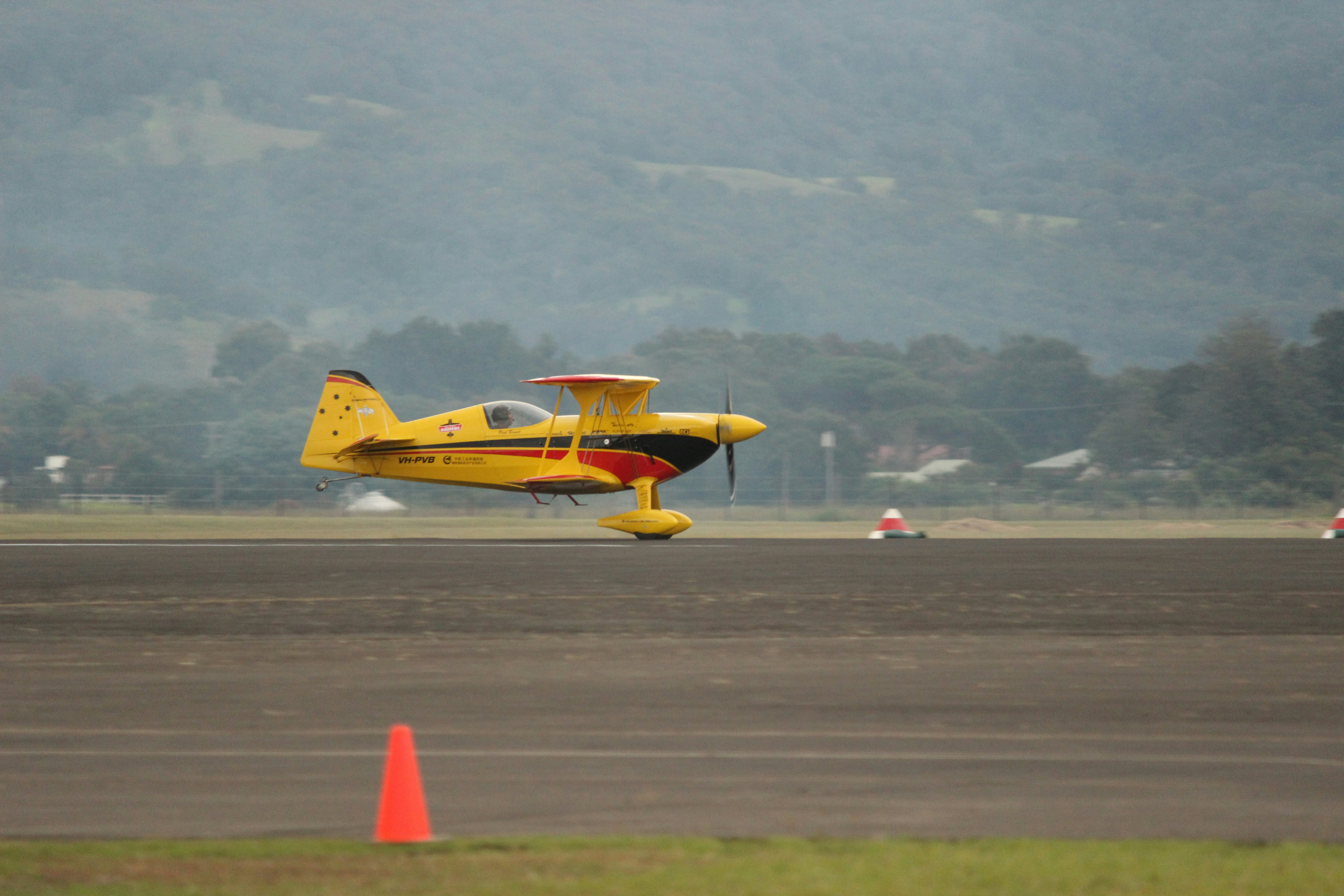 A small yellow plane taking off from an airport runway, Paul Bennett in his Wolf Pitts Pro at the Wings over Illawarra (Now Airshows DownUnder) Airshow 2017