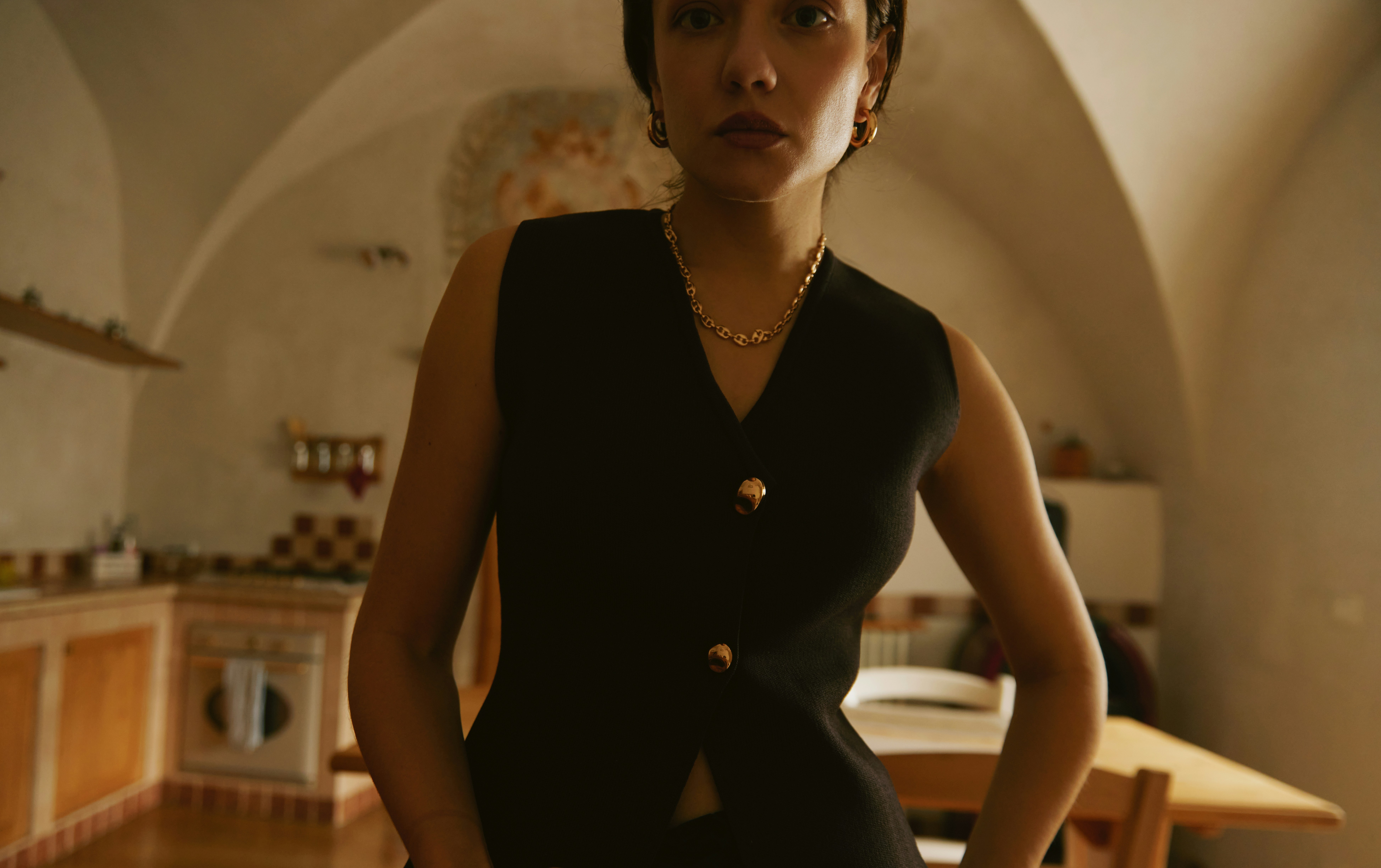 A woman in a black dress standing in a kitchen