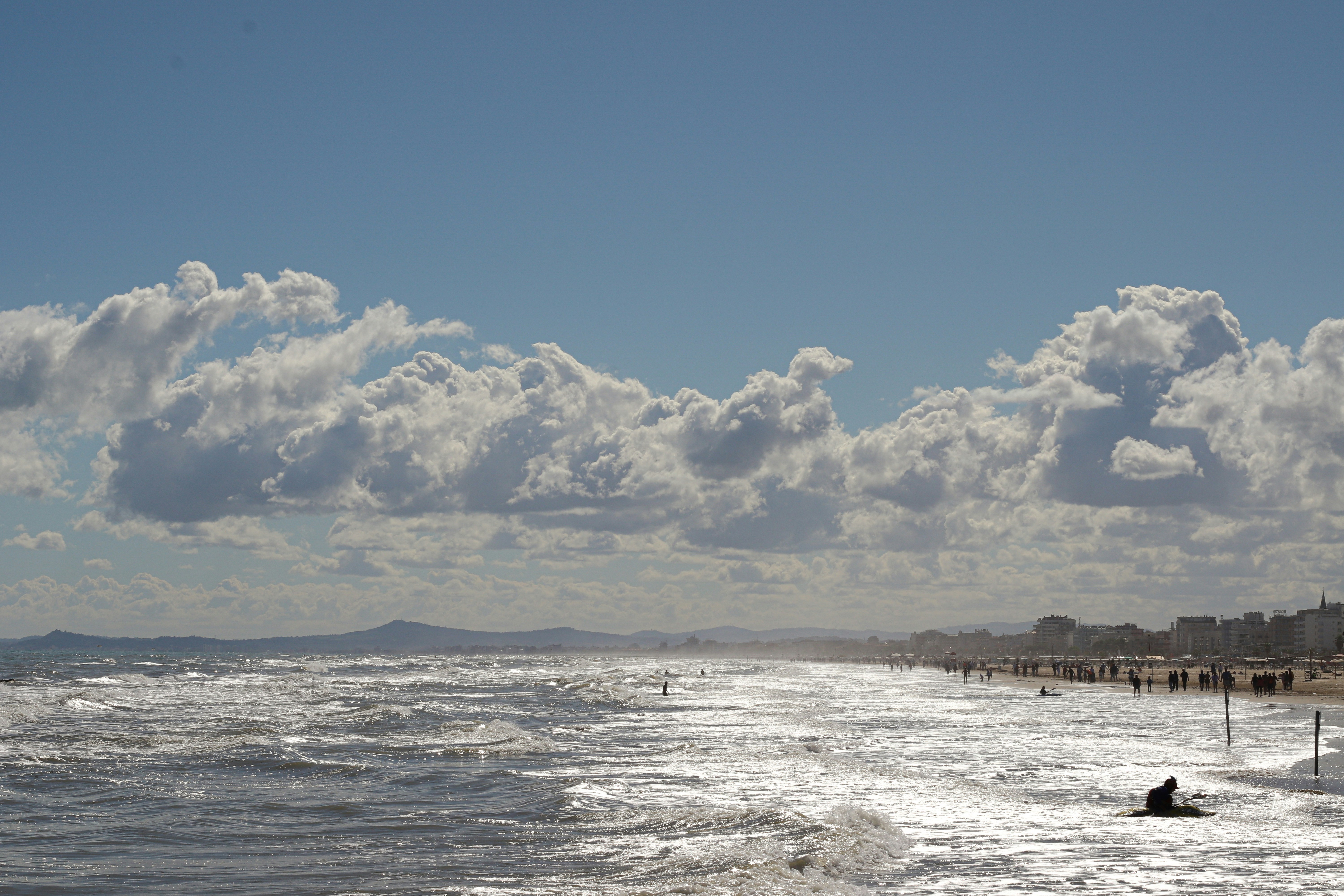 Eine Person, die auf einem Surfbrett auf einem wellenbedeckten Strand reitet
