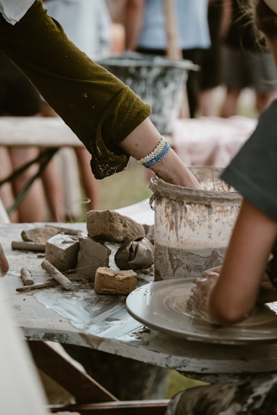 Two people are making pottery on a table