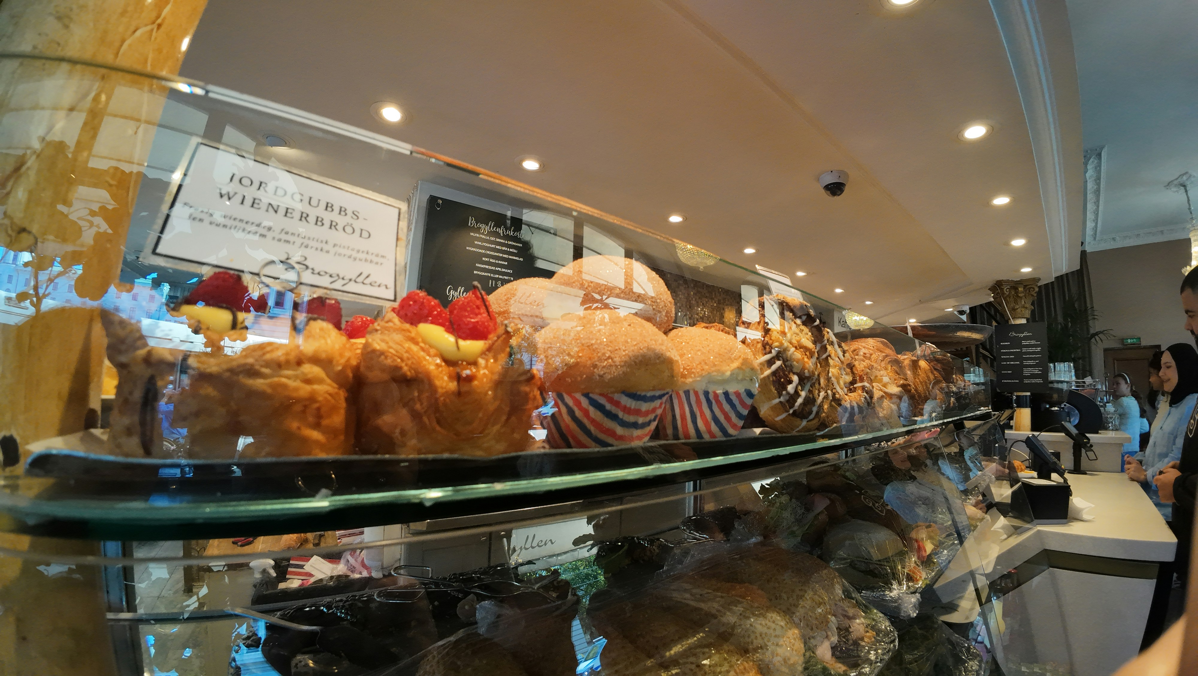 A woman standing in front of a display case filled with pastries