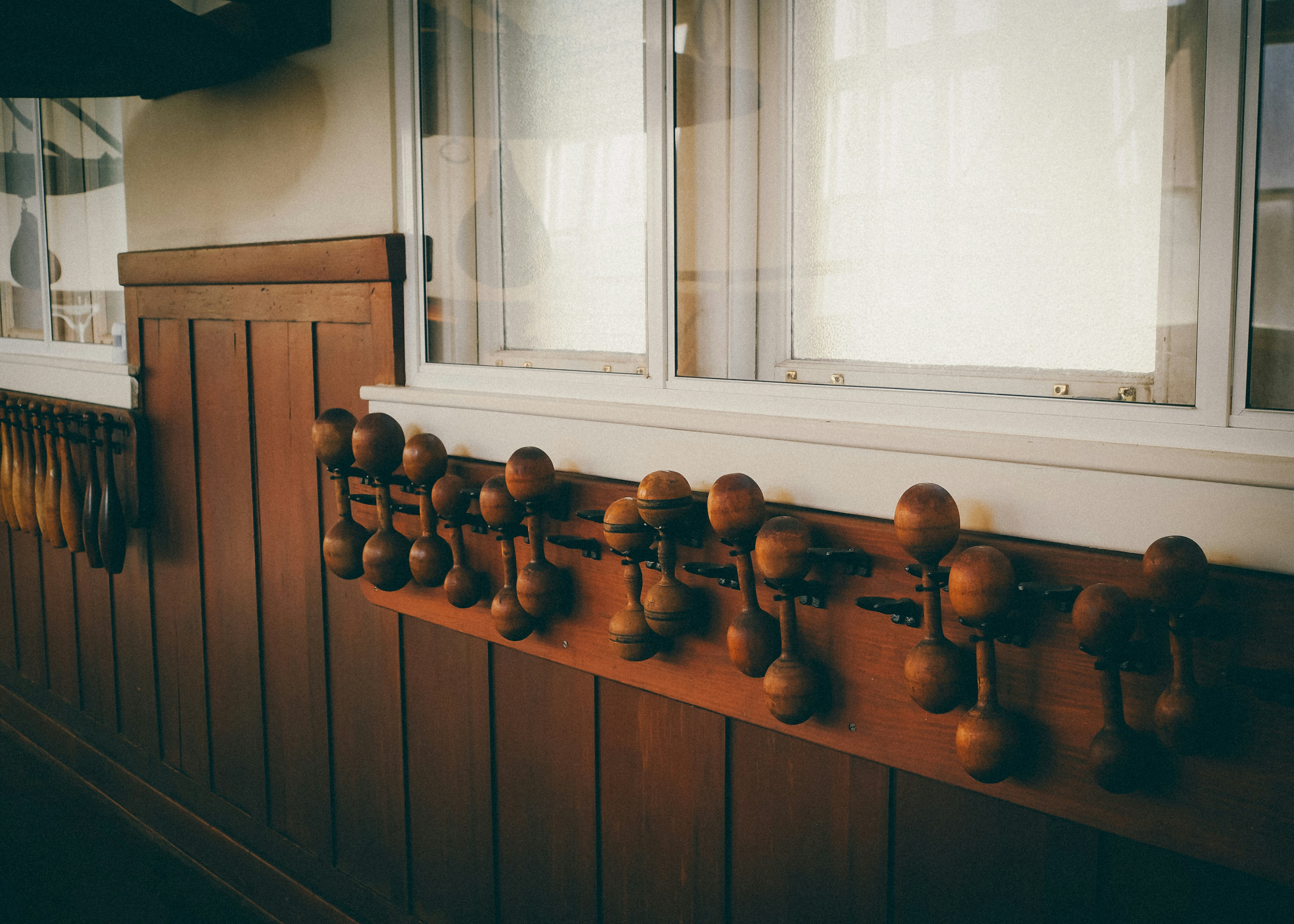 A number of knobs on a wall near a window