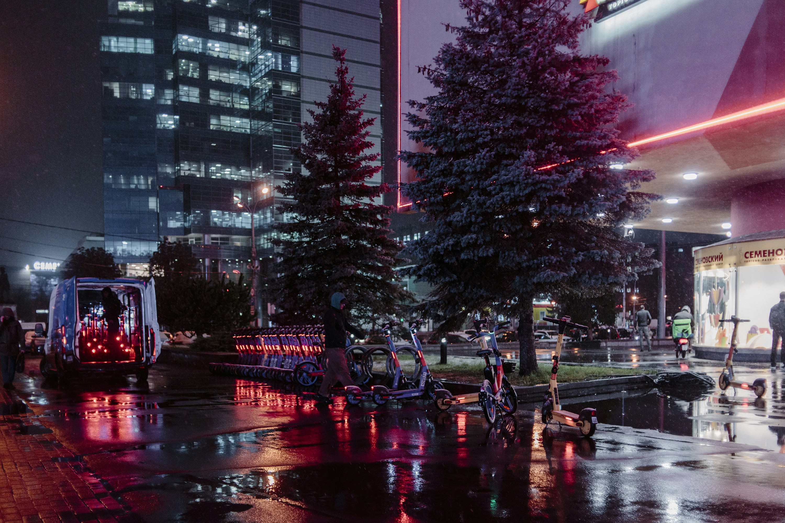 A group of people walking down a street at night