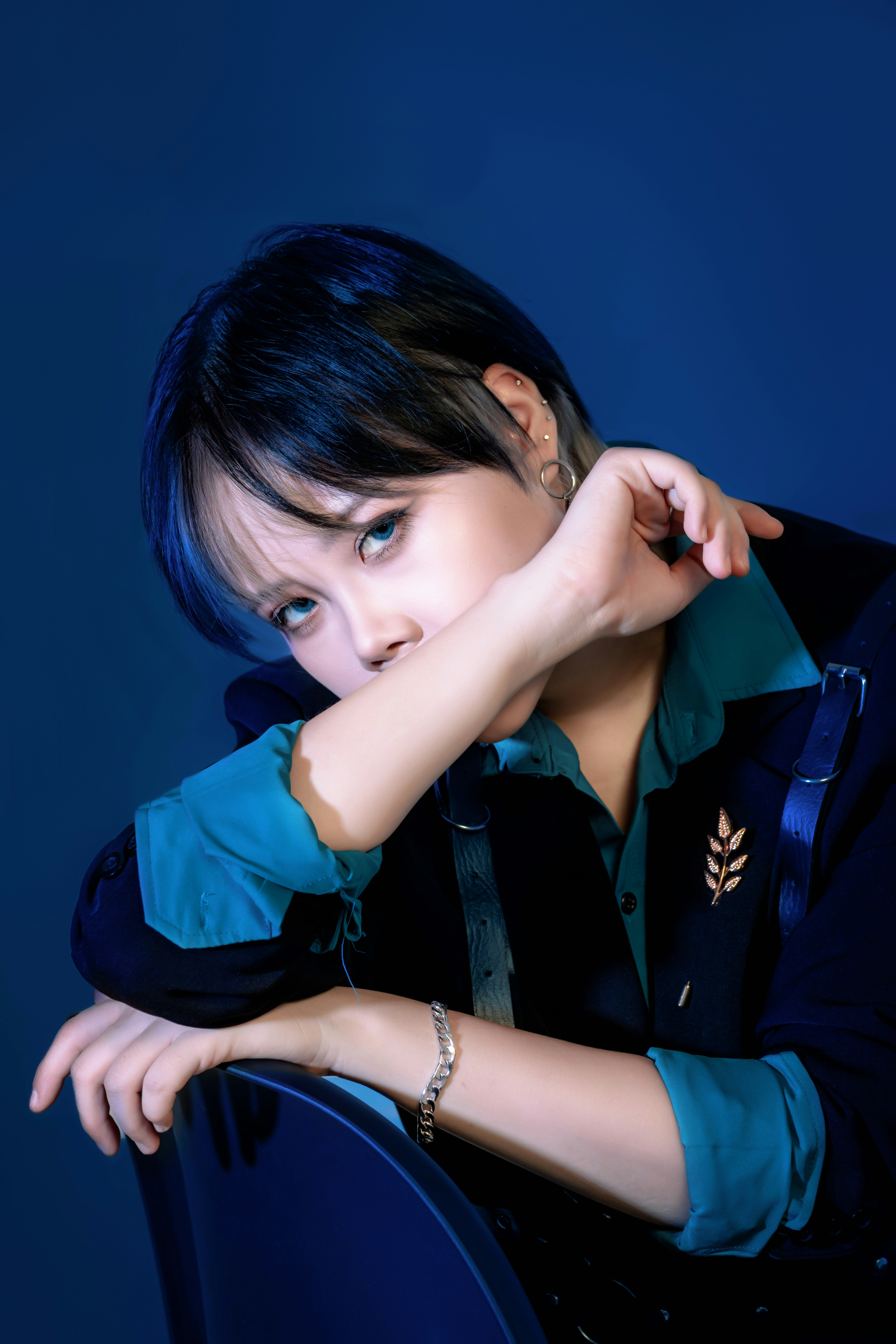 A woman sitting in a chair with her hand on her chin