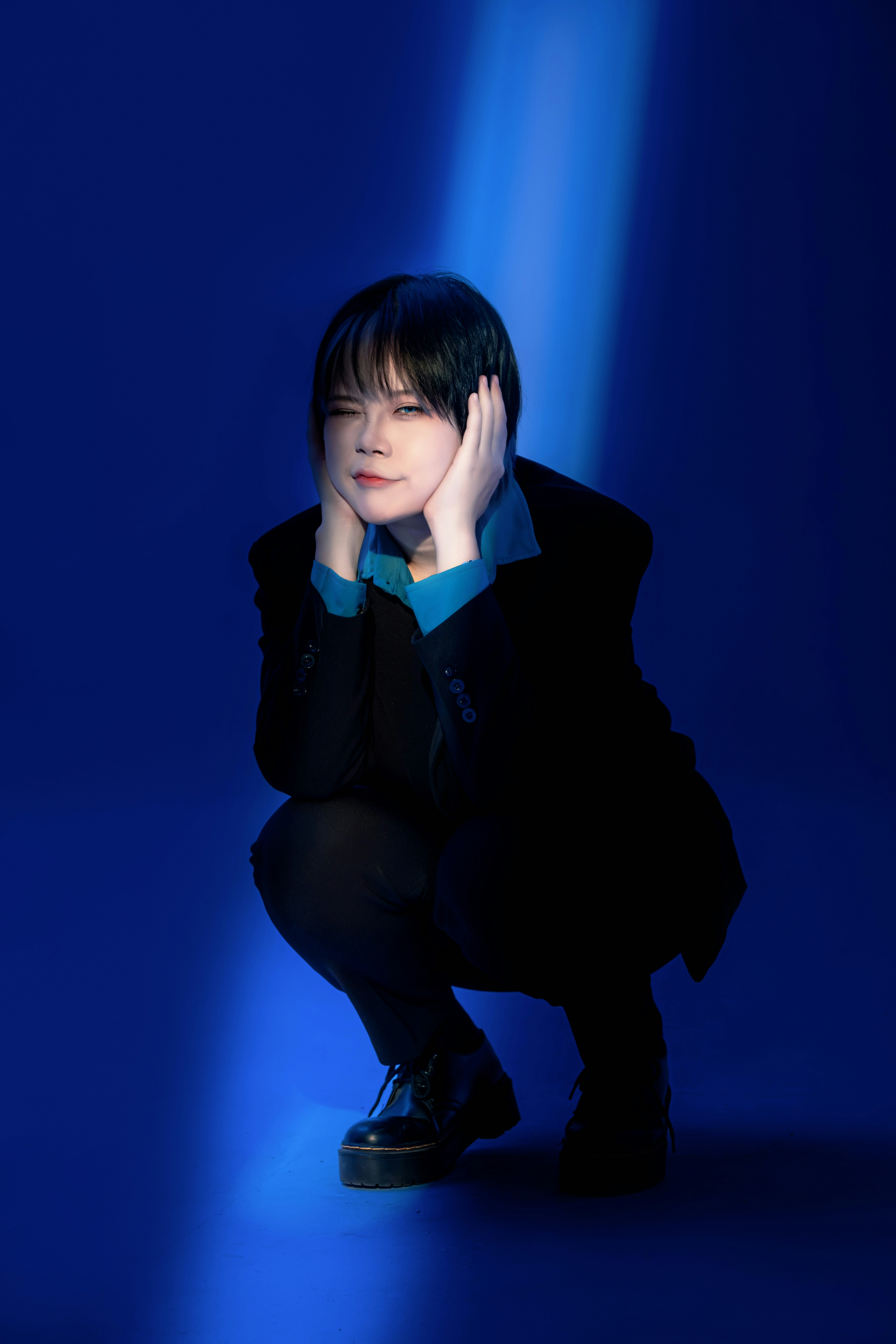 A person kneeling down with their hand on their head