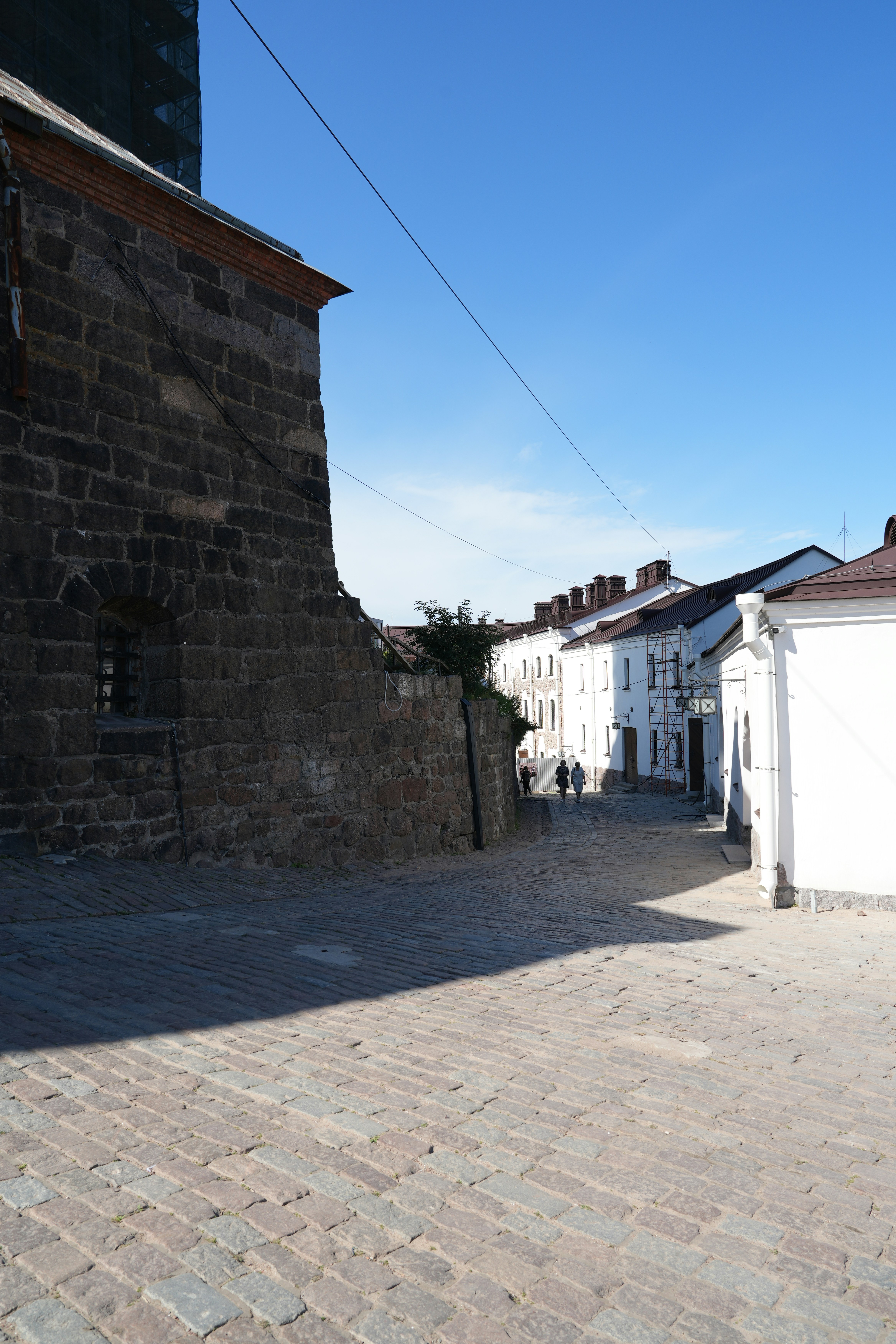 A cobblestone street with a brick building in the background