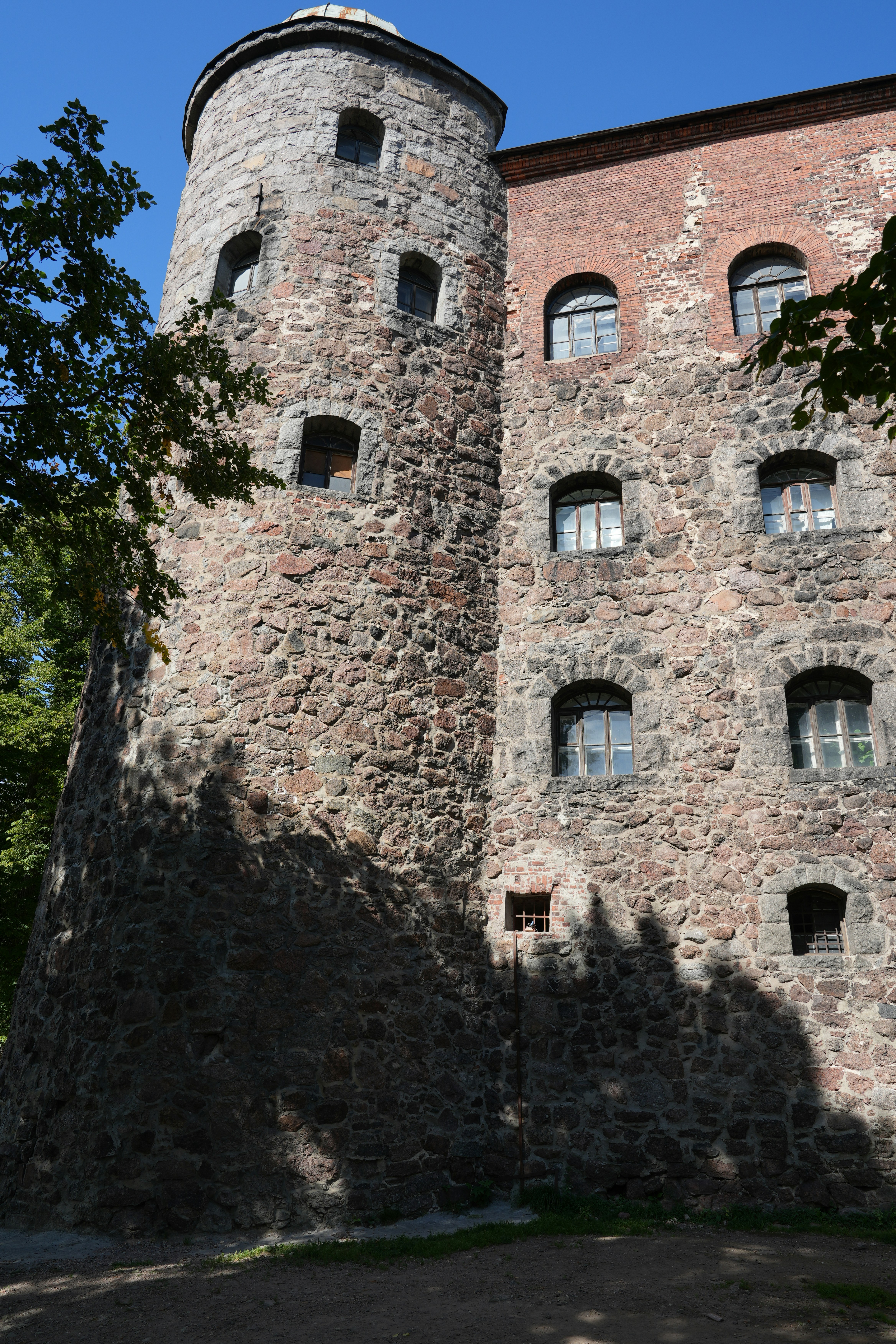 A tall brick building sitting next to a forest