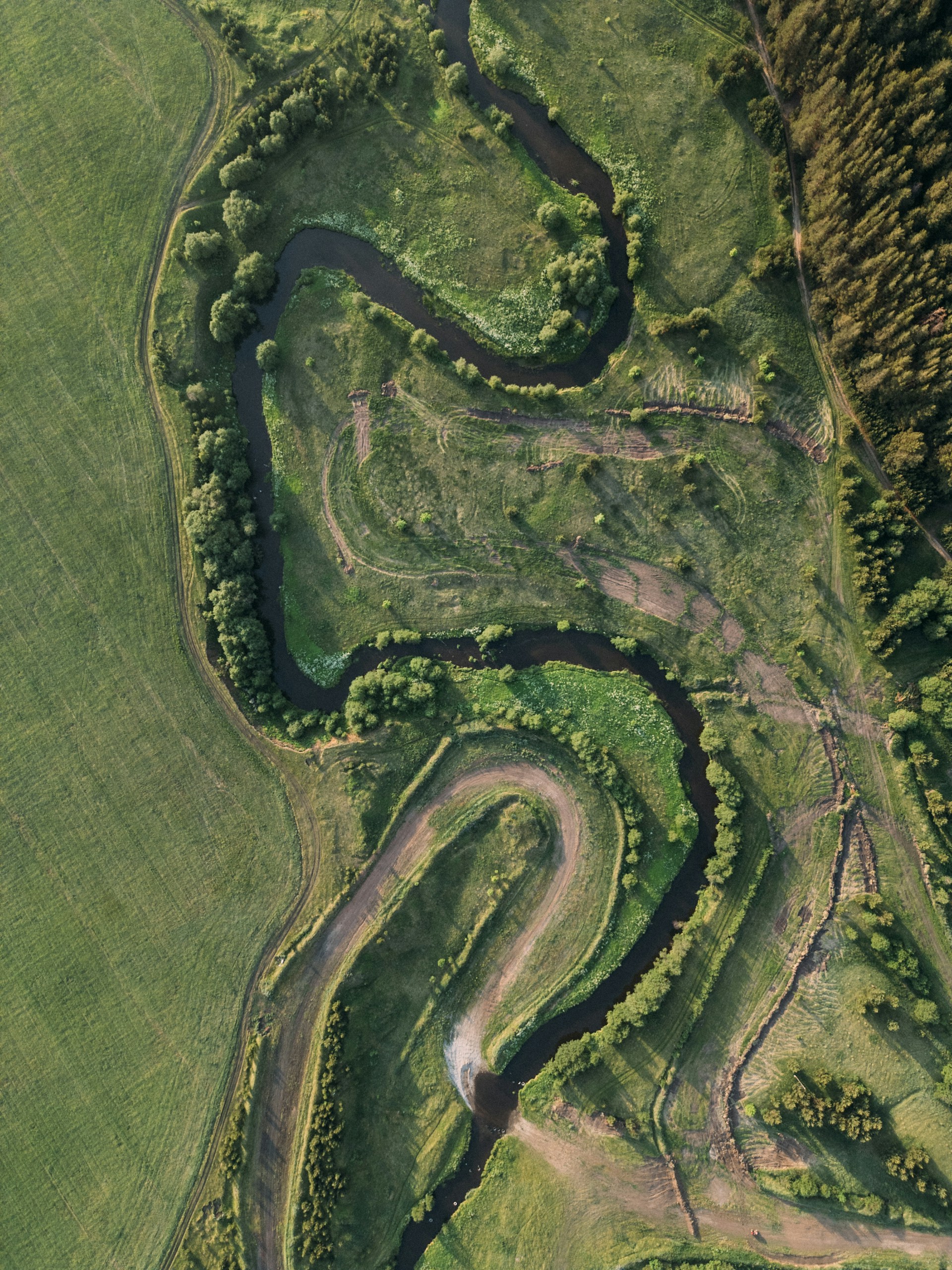 An aerial view of a dirt track in the middle of a field