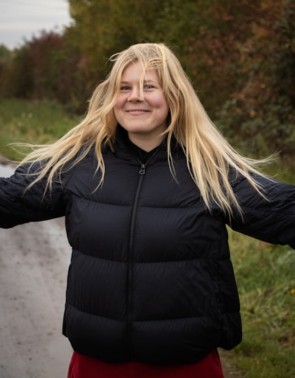 A woman standing on the side of a road