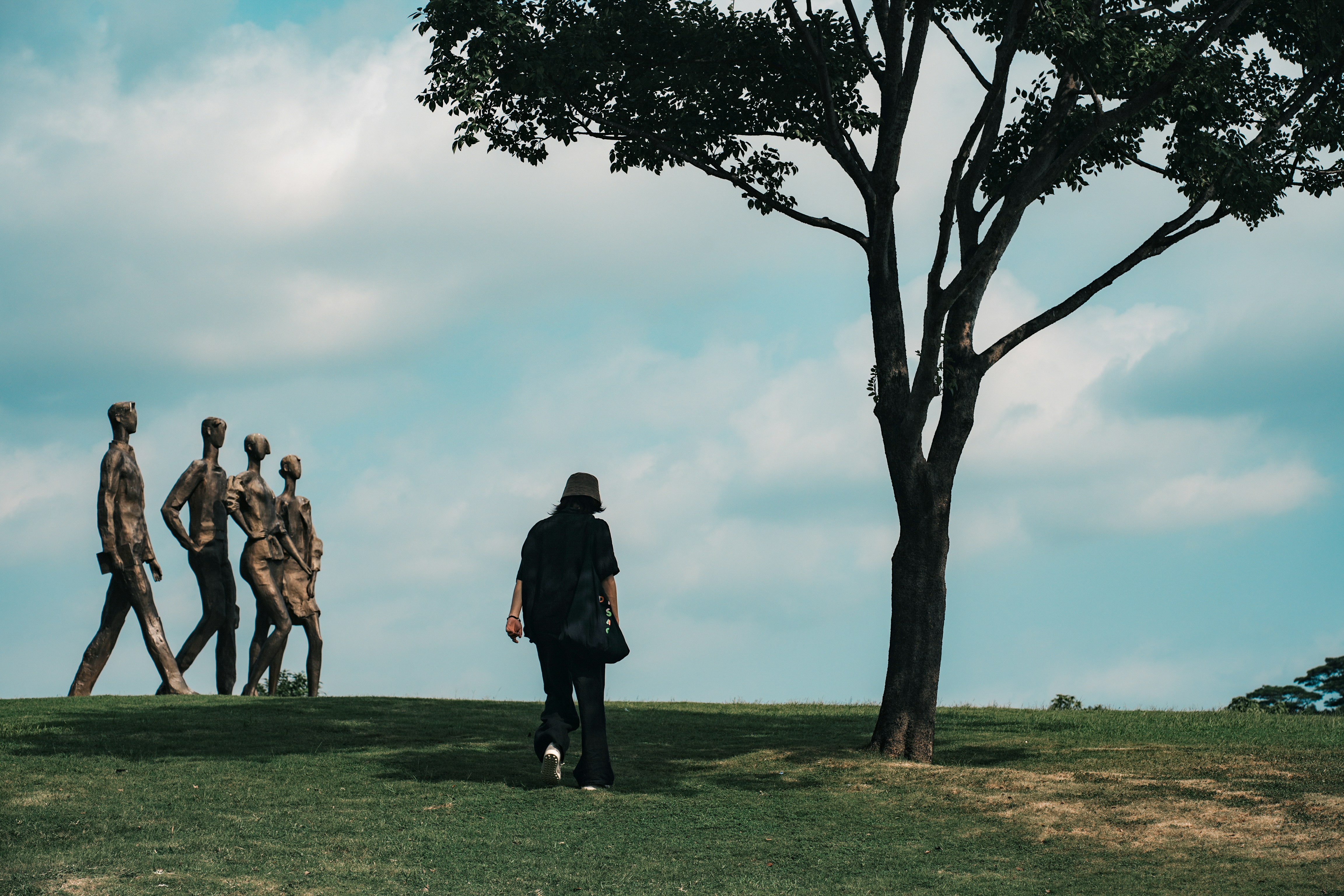 A group of people walking across a lush green field