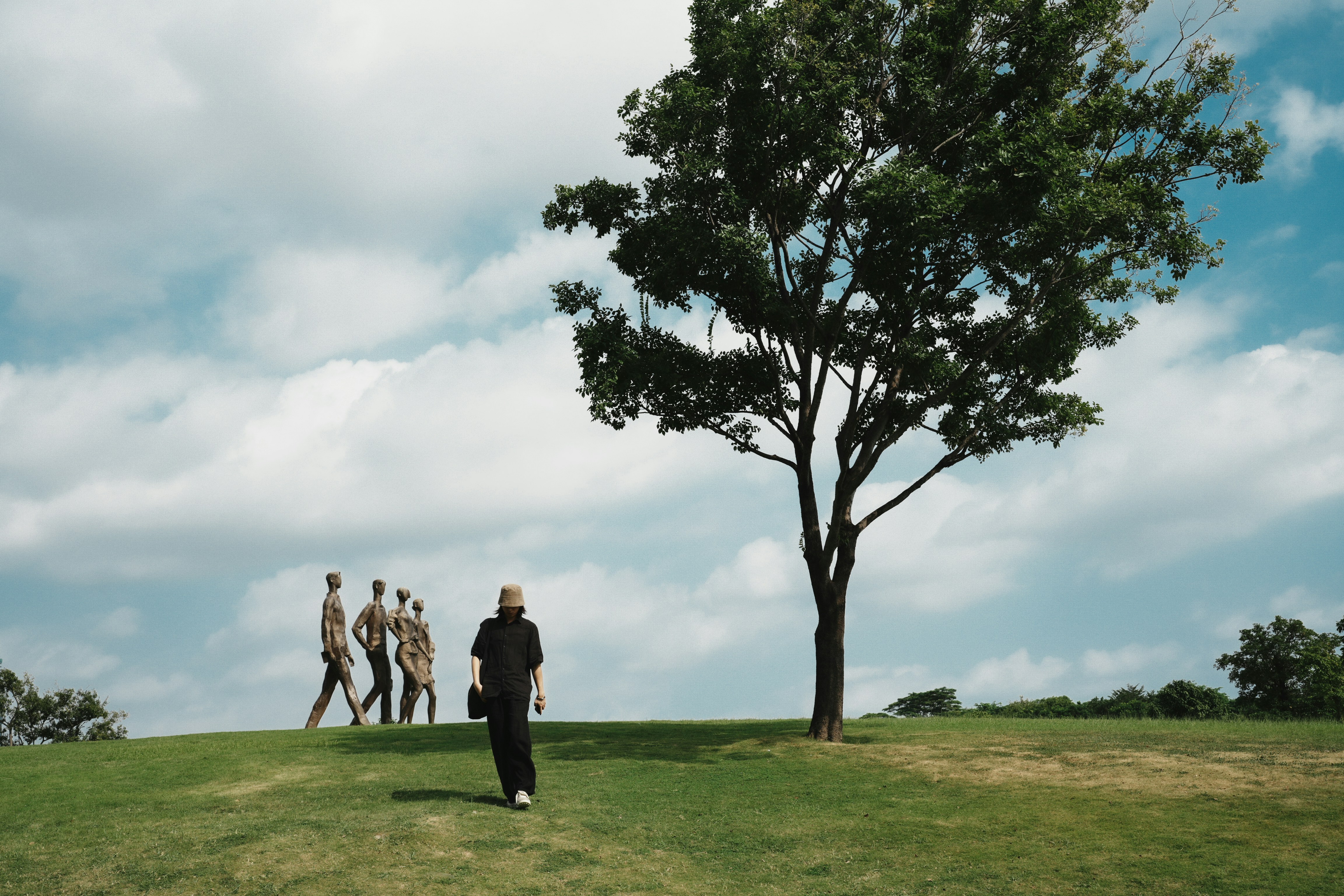 A group of people walking across a lush green field