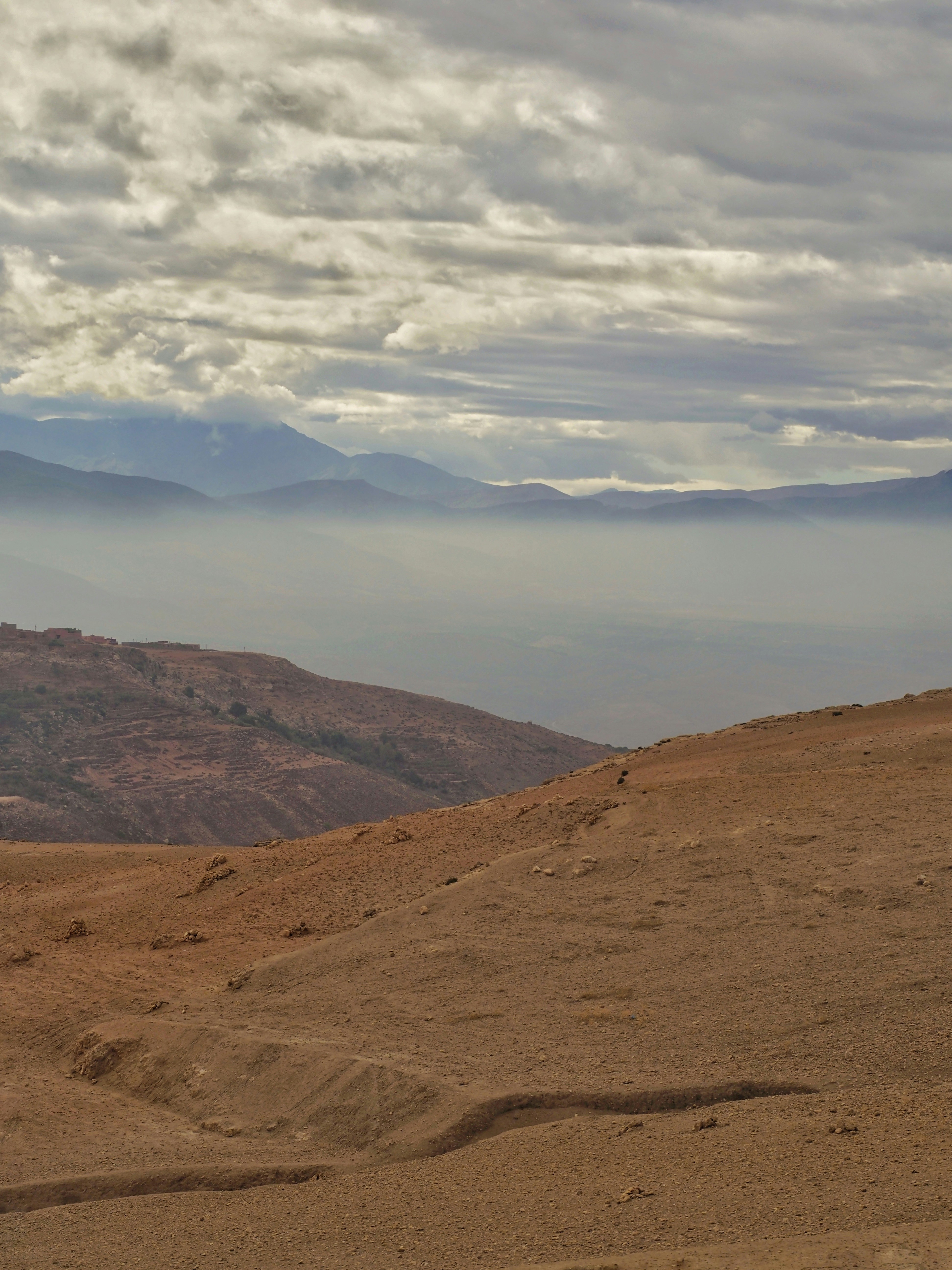 Cavalier sur un sentier de terre face aux montagnes de l'Atlas marocain