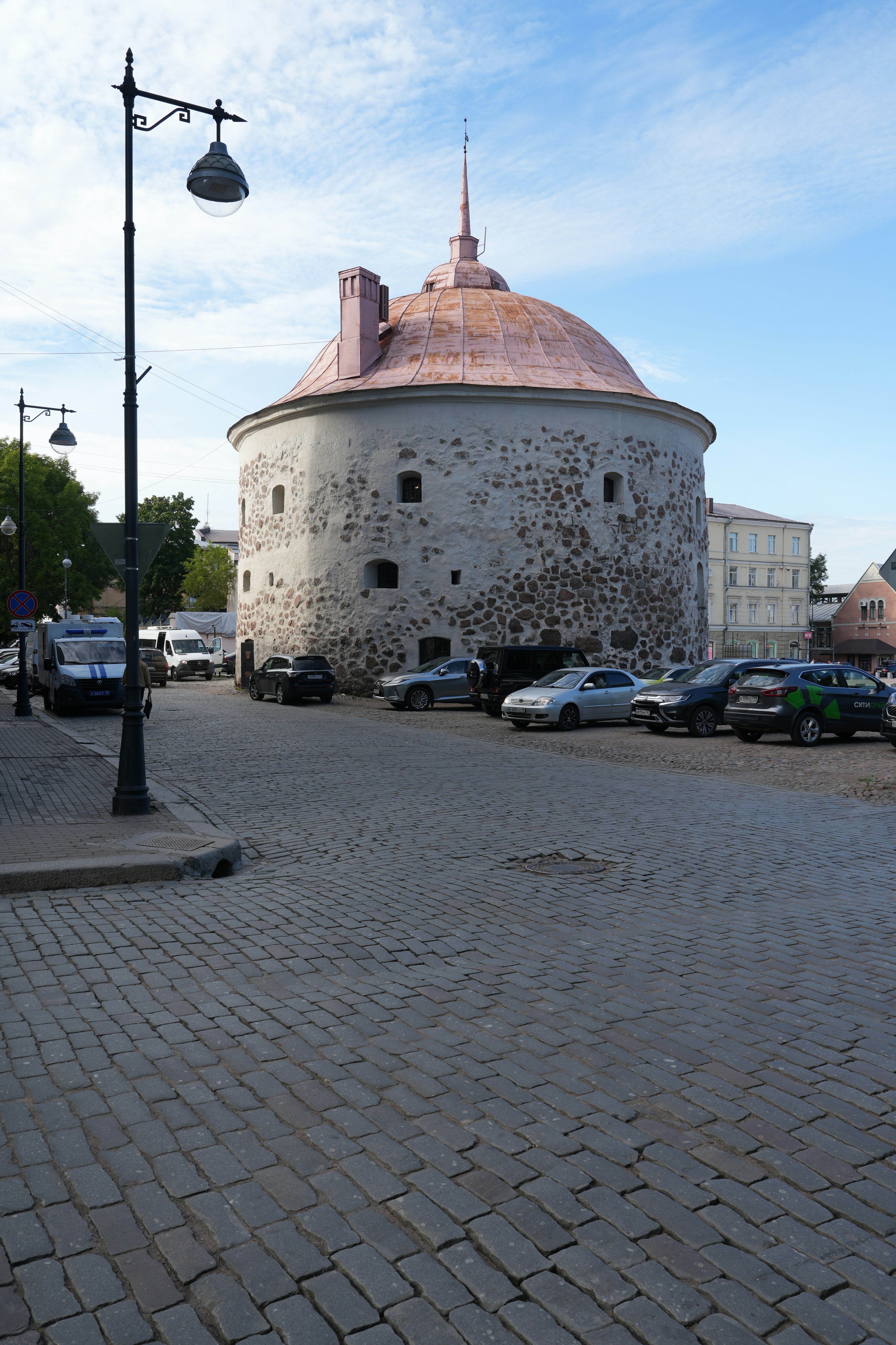 A brick road with a round building in the background