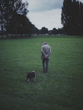 A man standing in a field with a dog
