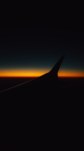 The wing of an airplane as the sun sets