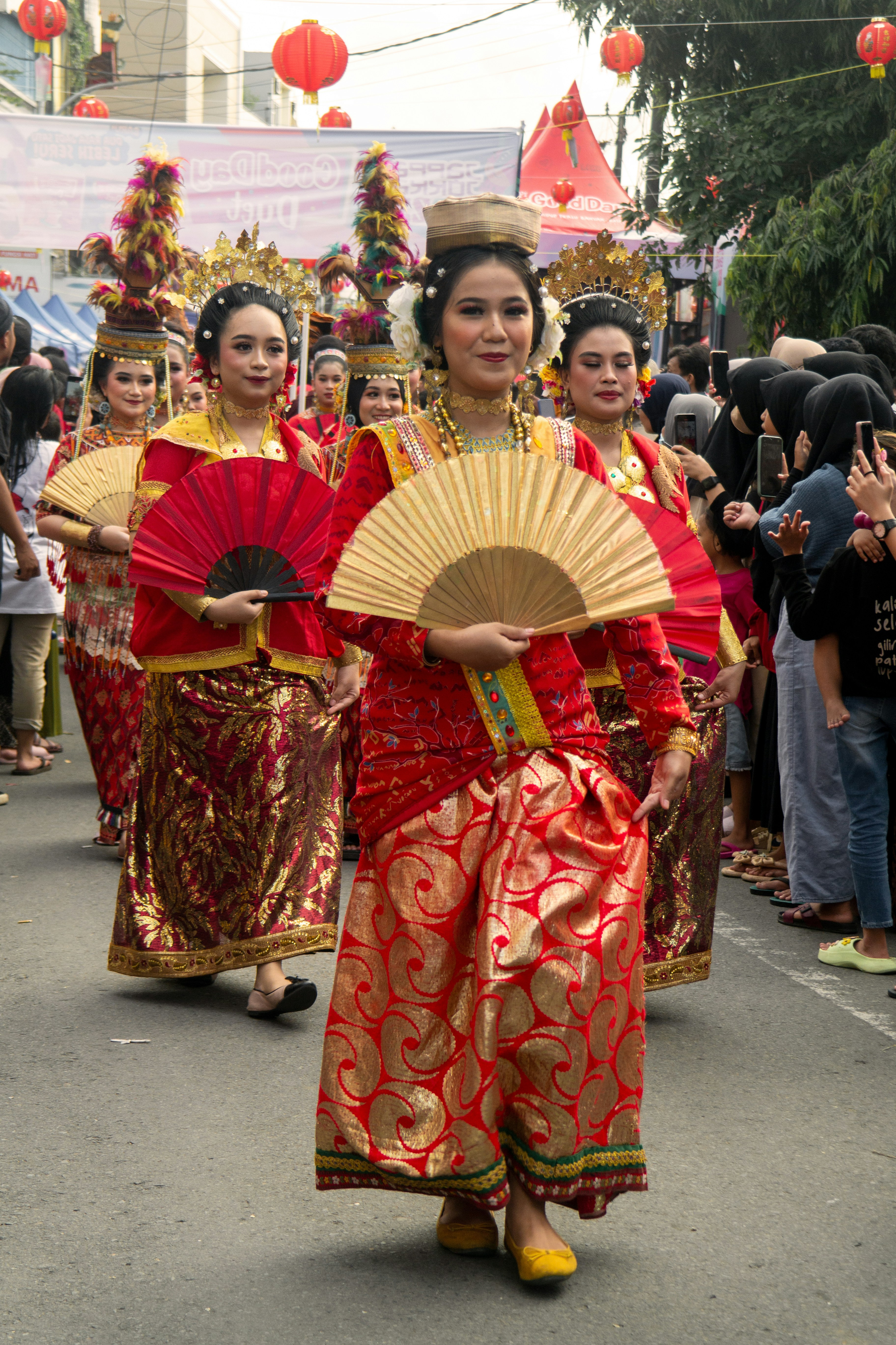 A group of women walking down a street holding a fan
